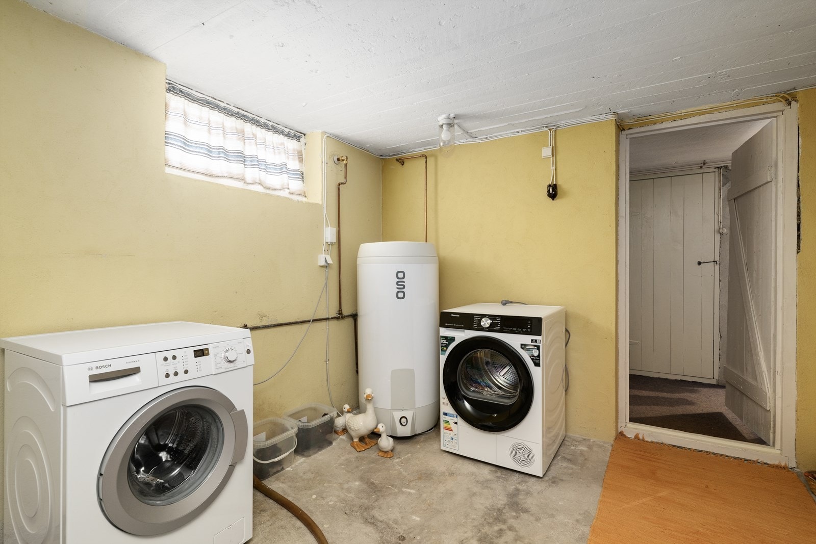 I kjelleren er det eget vaskerom fra byggeår, som i sin helhet består av betong overflater. Vaskerommet er av god størrelse, med plass til både vaskemaskin og tørketrommel. Varmtvannstanken fra 2023 på ca. 200 liter er plassert på vaskerommet. Galleribilde