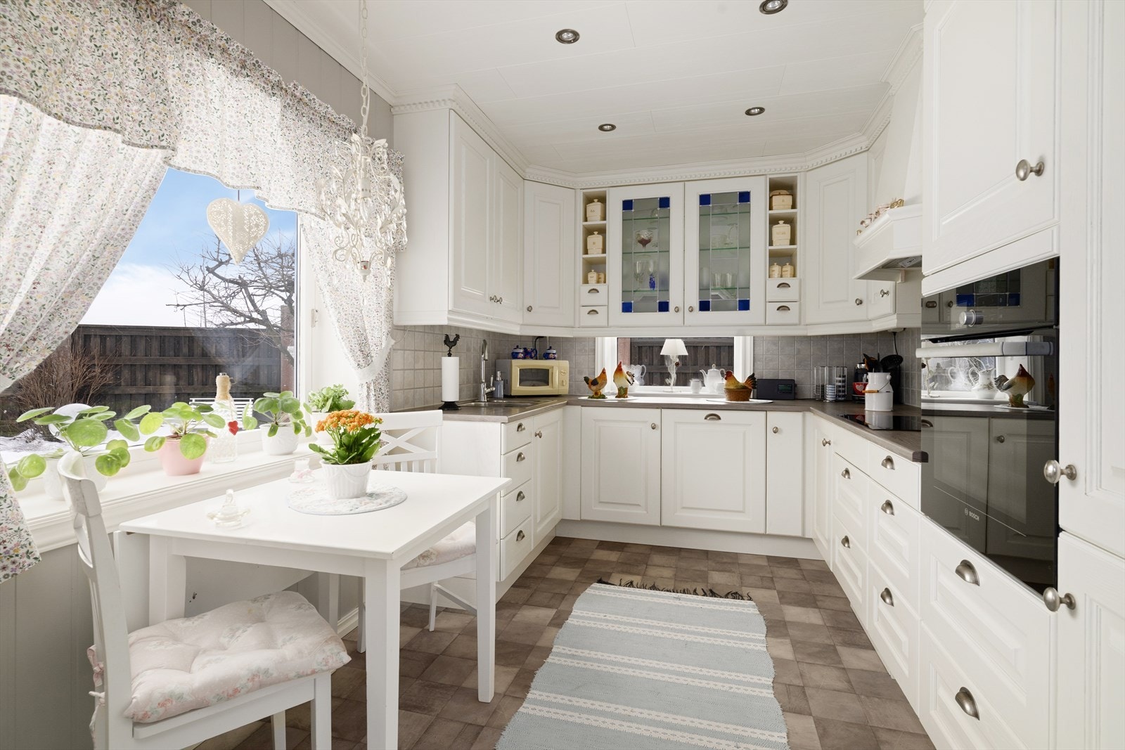 På kjøkkenet er det en koselig spiseplass ved vinduet med utsikt ut mot hagen. Galleribilde