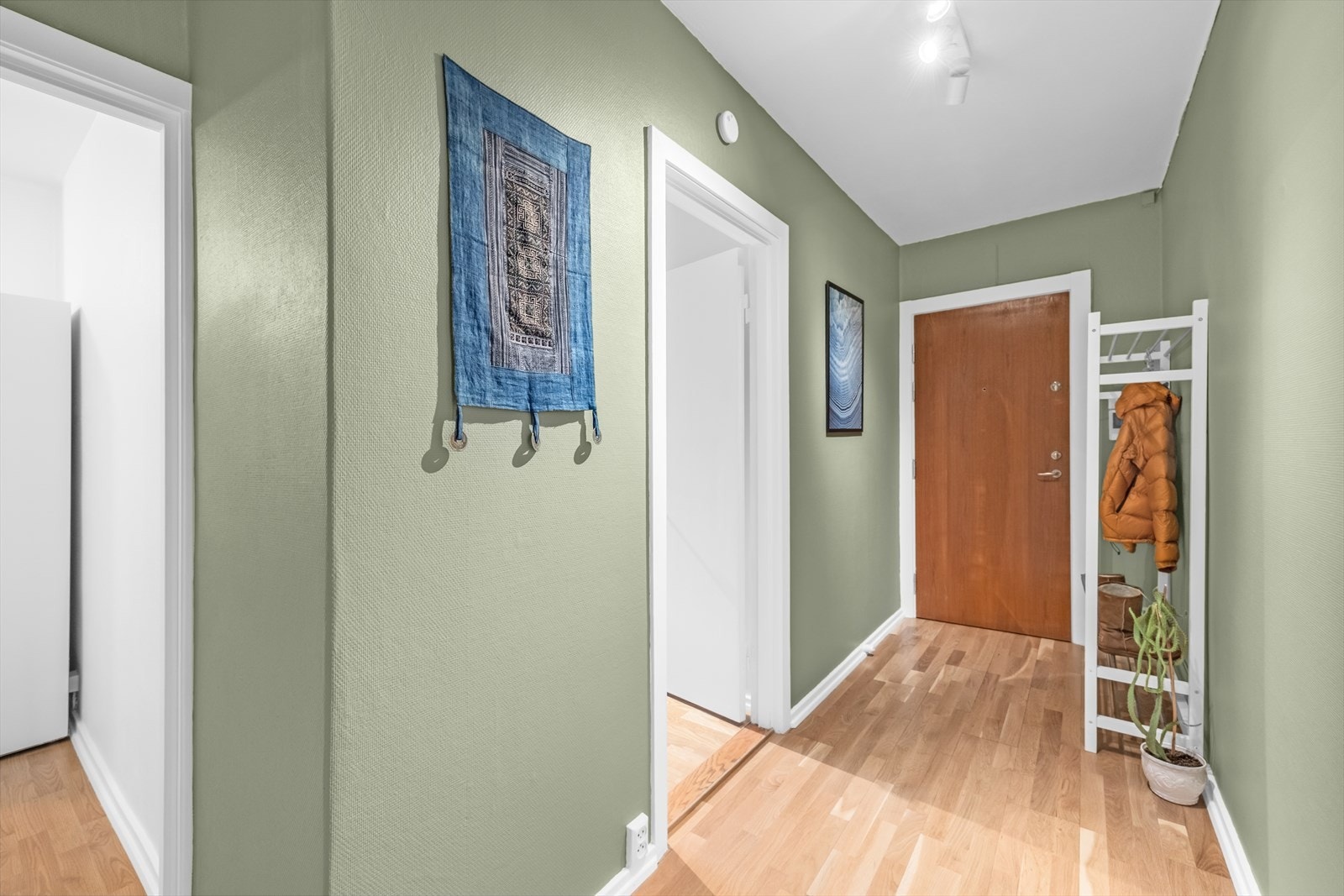 Romslig gang med god plass til å henge av seg ytterklær og sette fra seg skoene. Leiligheten er tilknyttet felles callinganlegg med automatisk åpner og video. Galleribilde