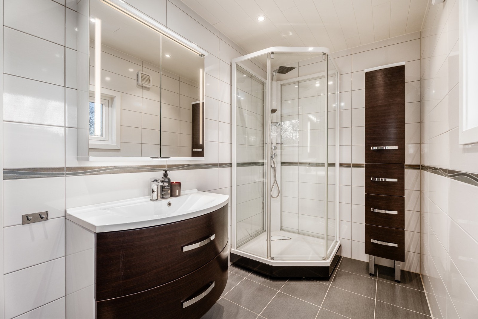 Lyst, flislagt bad med rikelig oppbevaringsplass. Galleribilde