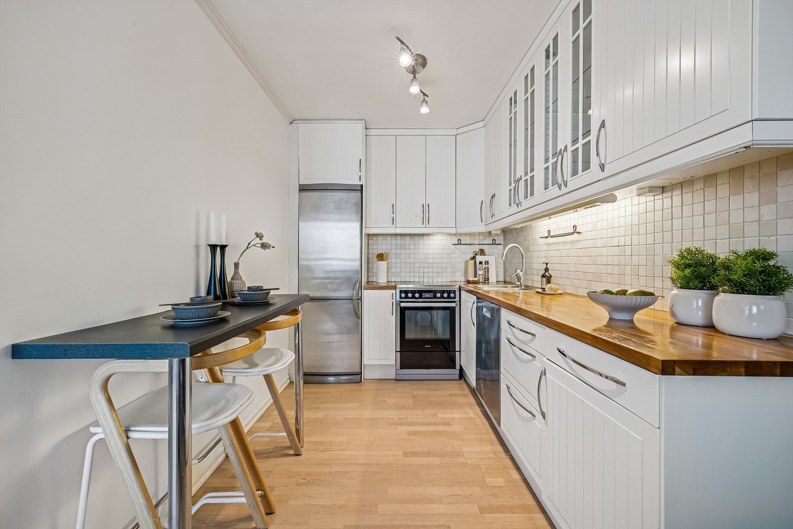 Moderne og stilrent kjøkken med god skapplass og naturlig lys Galleribilde