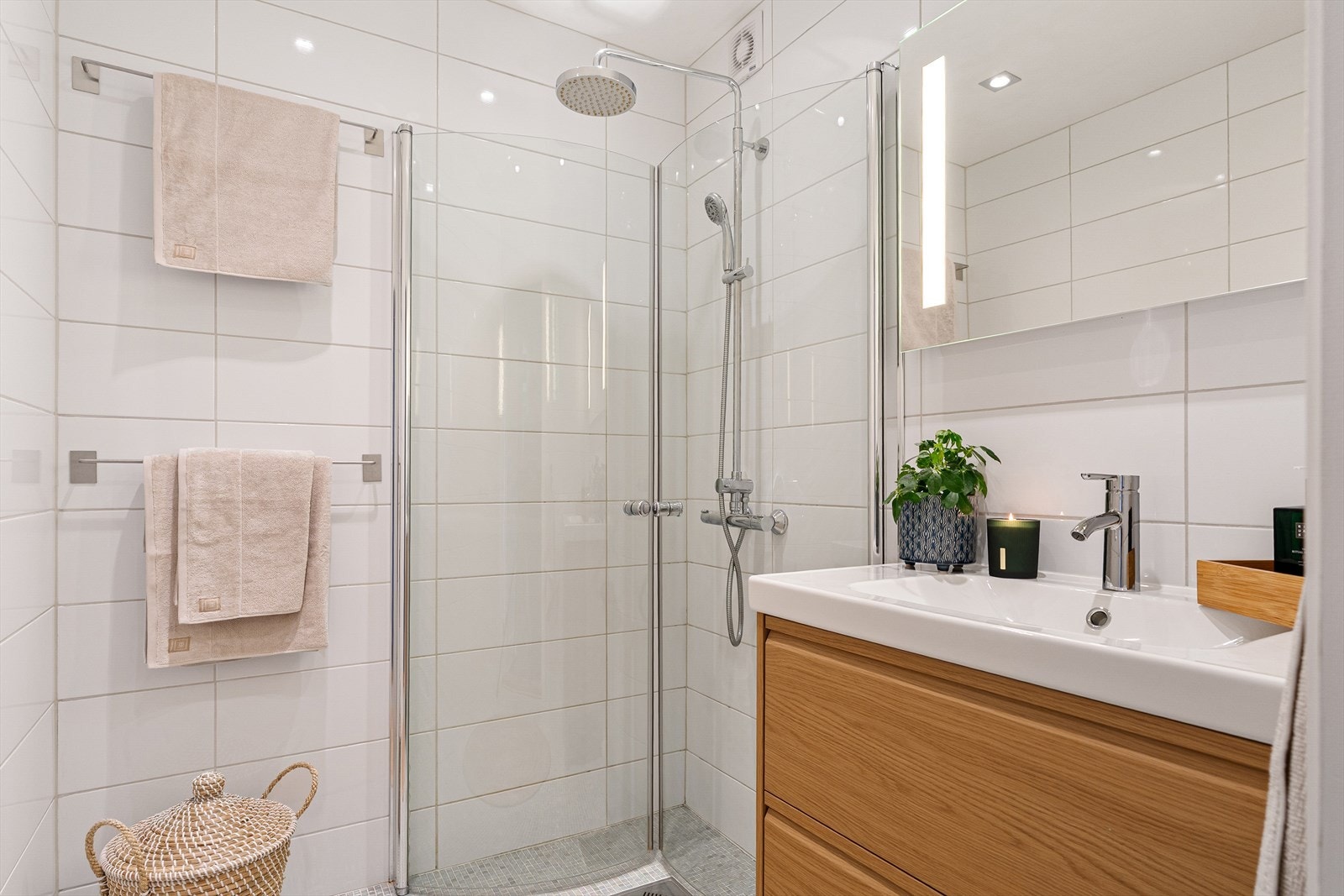 Delikat og flislagt bad utstyrt med praktisk baderominnredning. Galleribilde