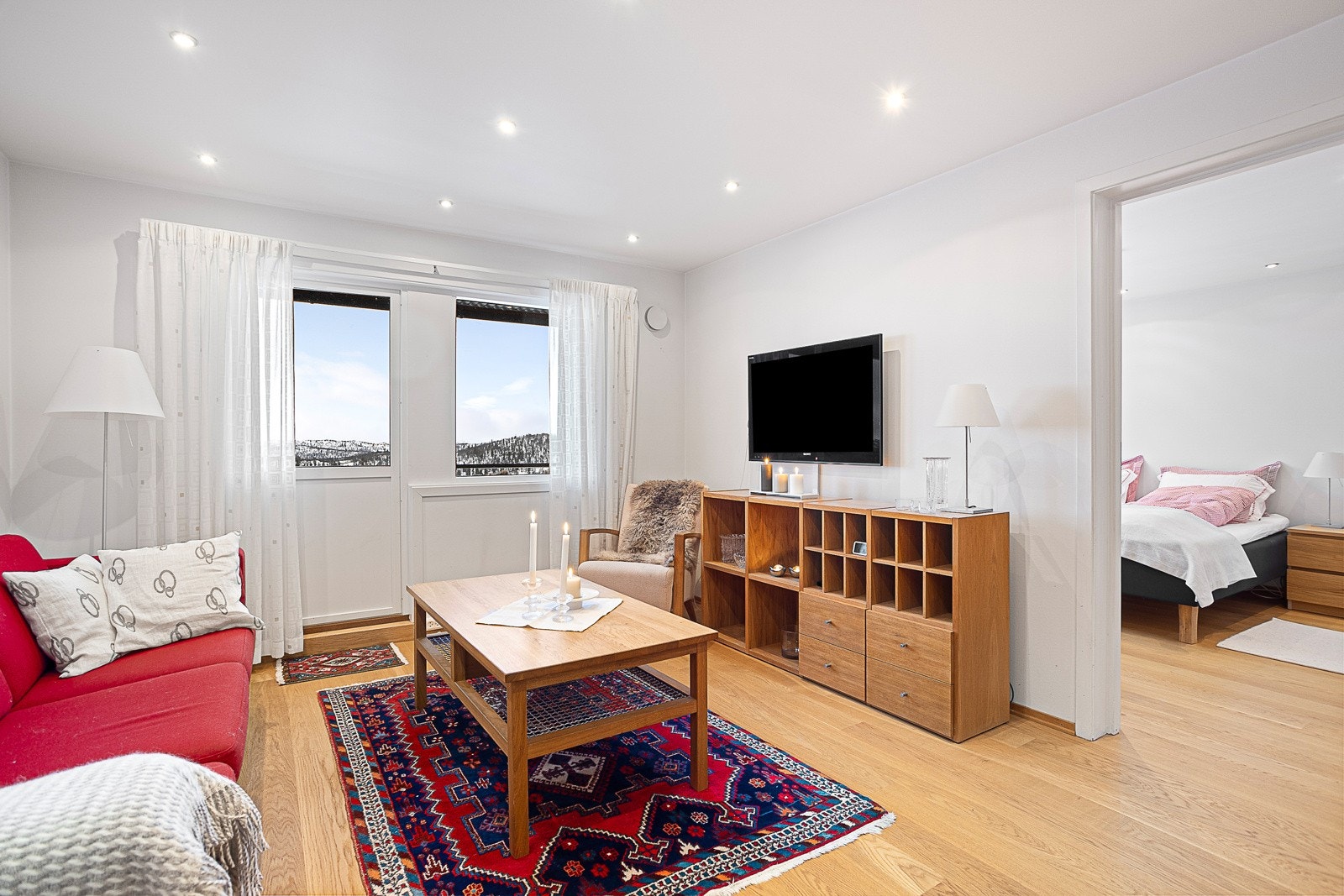 Et lyst og innbydene rom med downlights i himlingen. Fra stuen er det utgang til en solrik balkong. Galleribilde