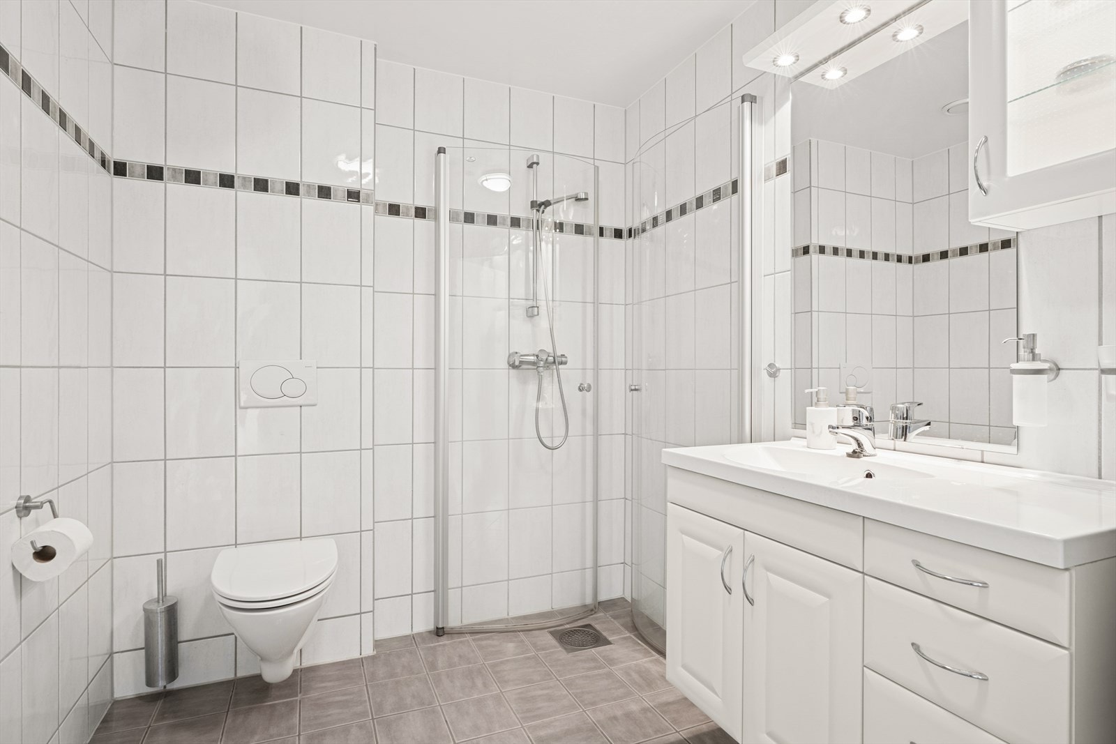 Gulvet er belagt med lysegrå fliser og har behagelige, elektriske varmekabler - som gir ekstra komfort. Galleribilde