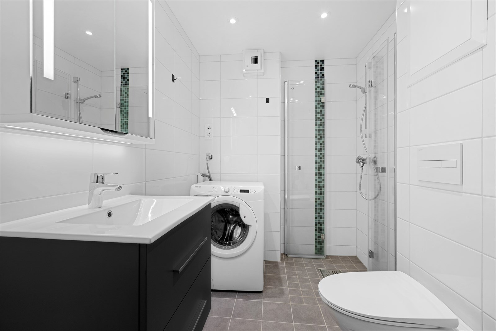 Bad med dusjhjørne og uttak til vaskemaskin Galleribilde