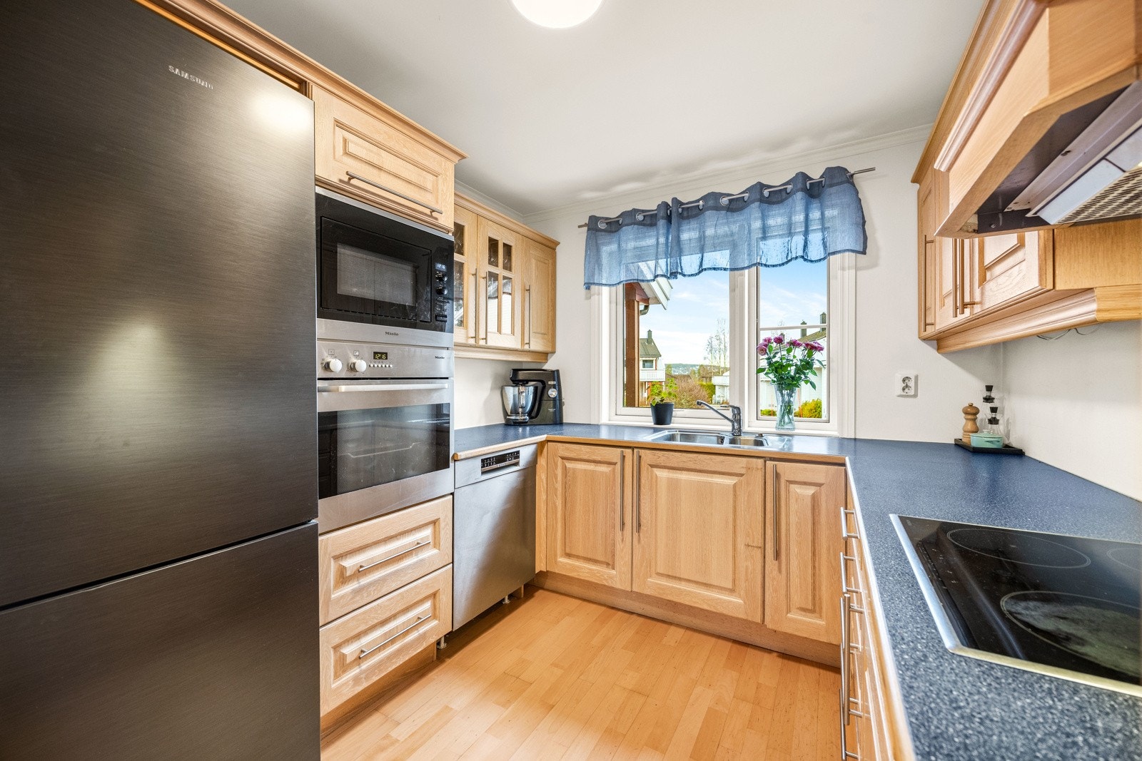 Innerst i rommet ligger kjøkkenet. Her er det vindu over benken noe som gir gjennomlys i hele allrommet. Galleribilde