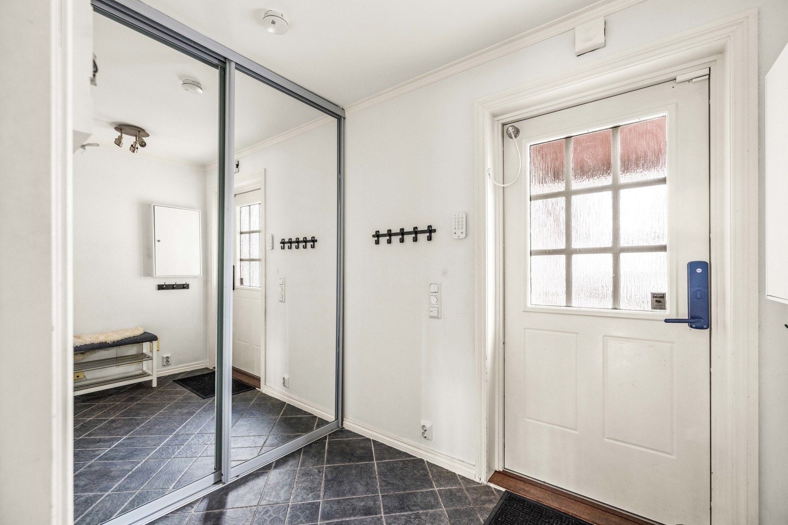 Flislagt entré med skyvedørsgarderobe. Ytterdøren er utstyrt med Yale doorman kodelås (2025). Galleribilde