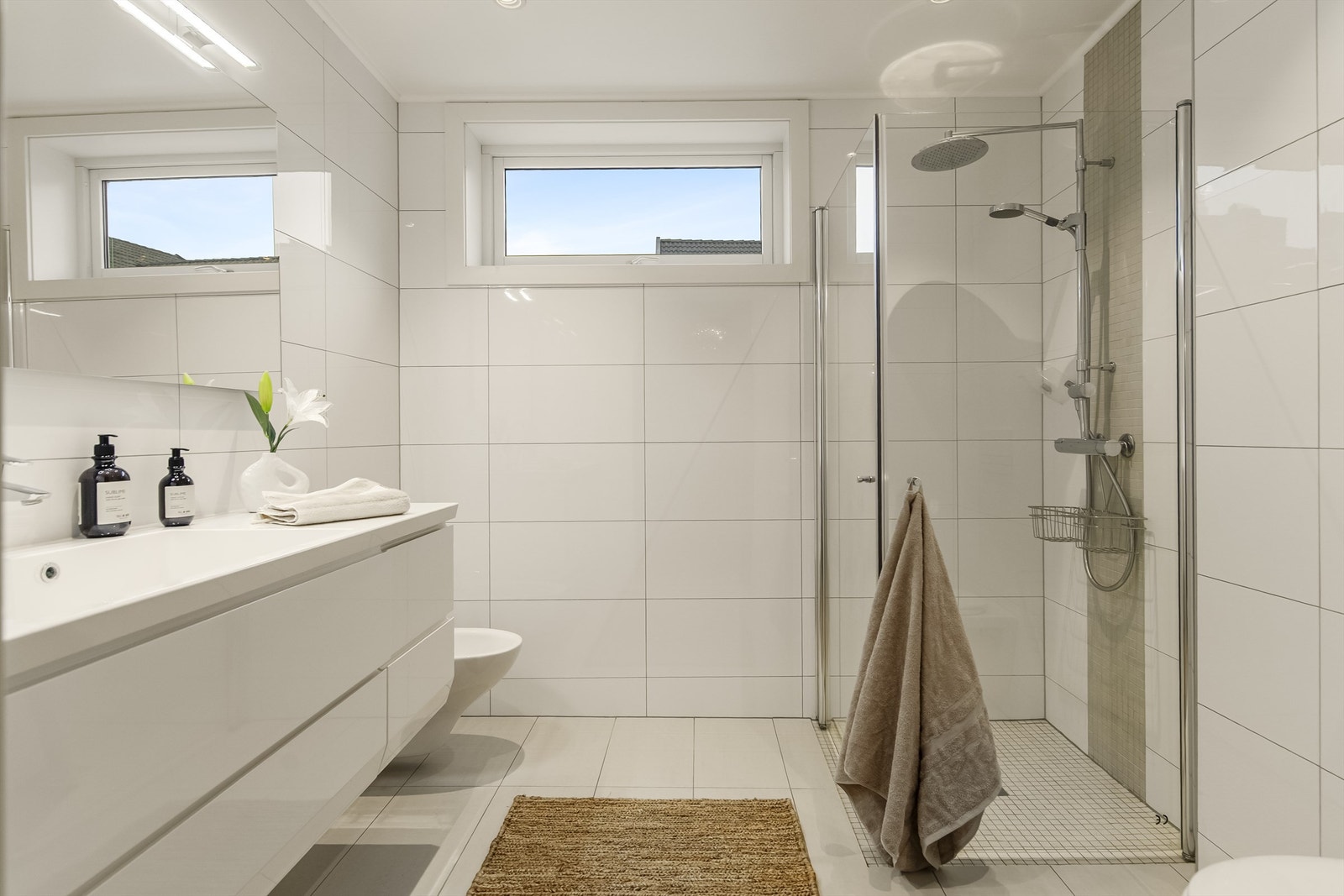 Lekkert bad i tidløse flisevalg og med vannbåren varme i gulv Galleribilde