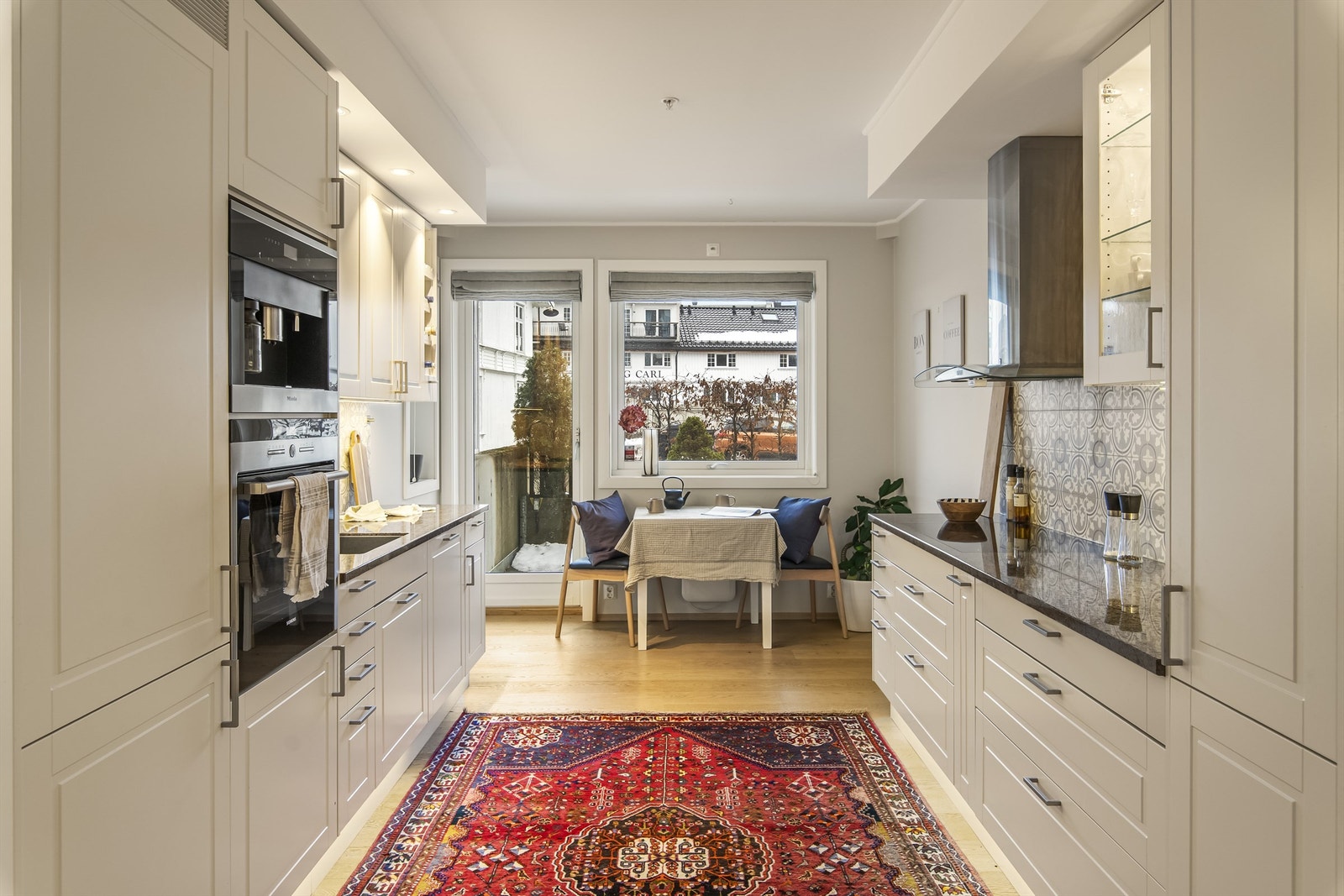 Smakfullt kjøkken med hvitprofilerte fronter og integrerte hvitevarer Galleribilde