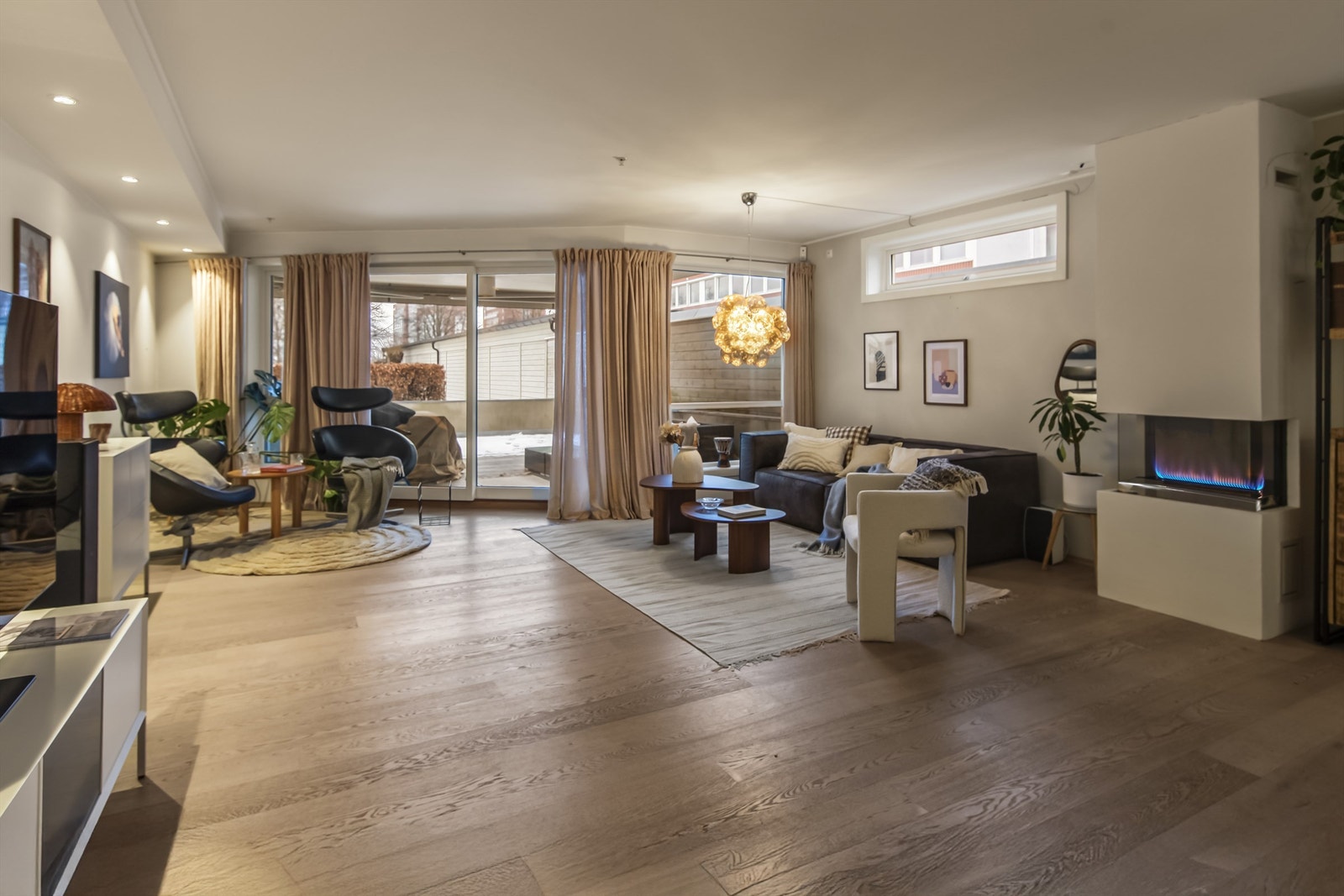 Stuen er lys og innbydende med naturlig lys fra store vindusflater og utgang til stor terrasse Galleribilde