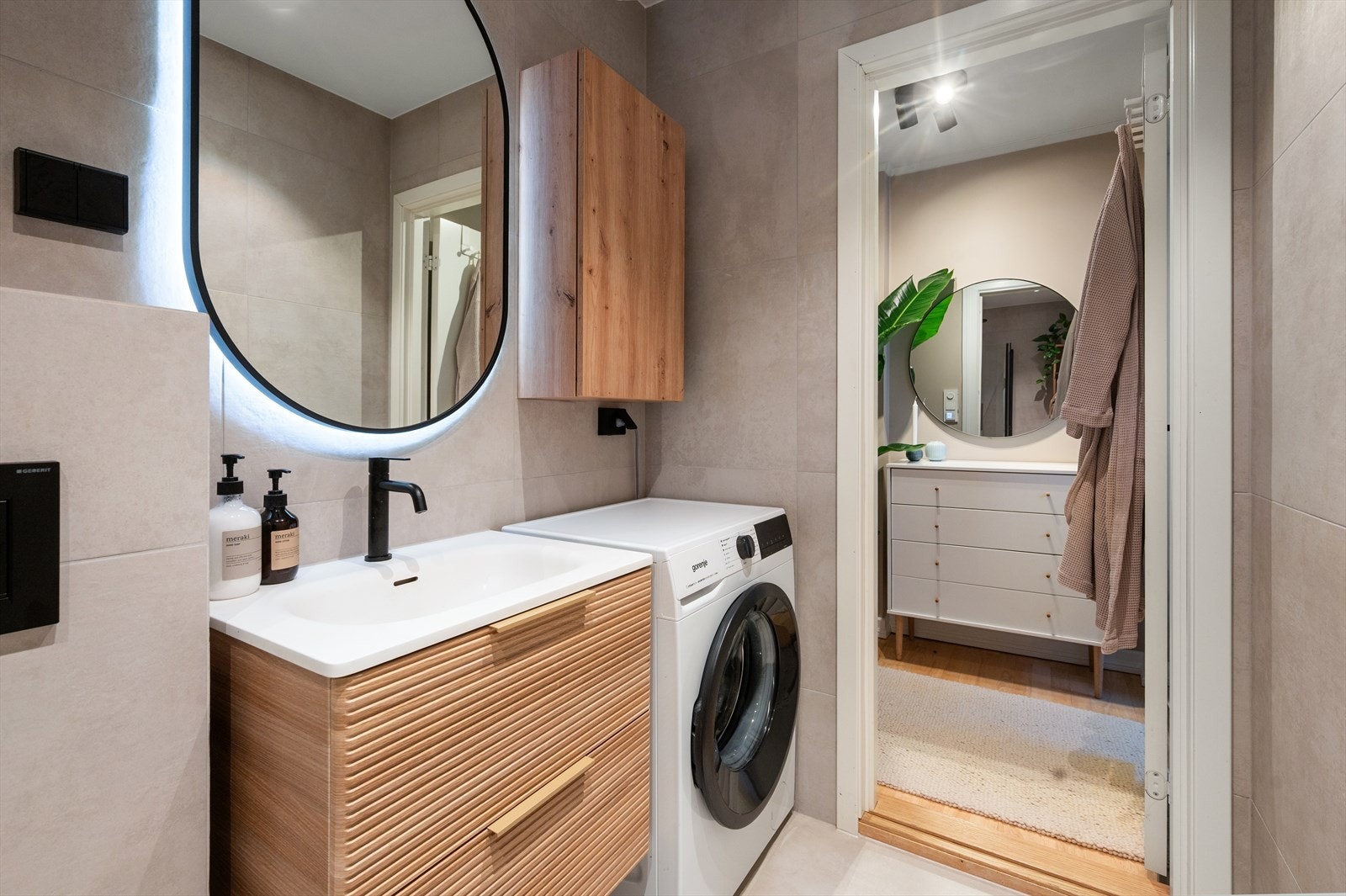 Badet er utført med lyse fliser og sort baderomsarmatur, som gir rommet et moderne uttrykk. Galleribilde