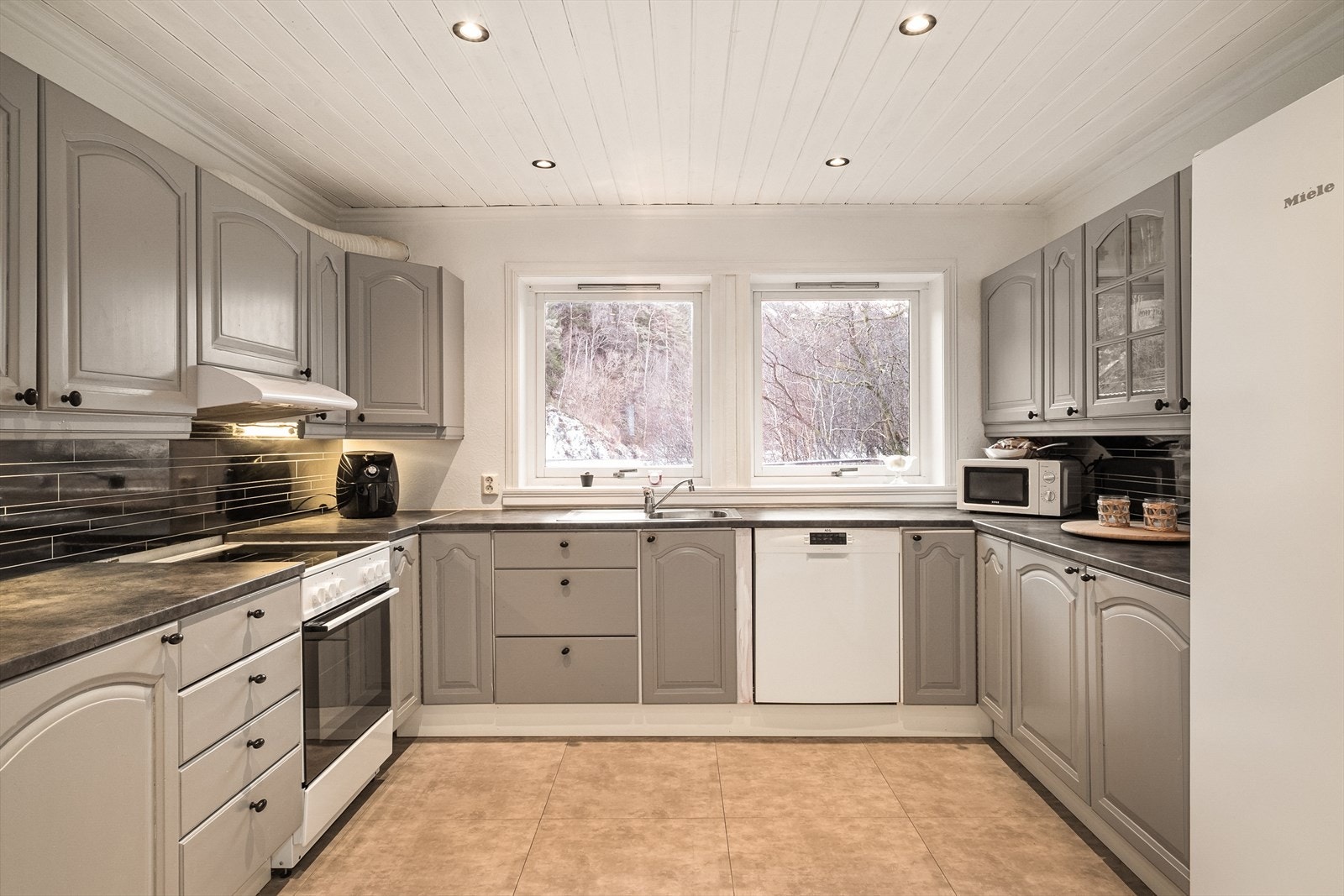 Kjøkken med spotter i taket og fliser med varme i gulvet. Galleribilde