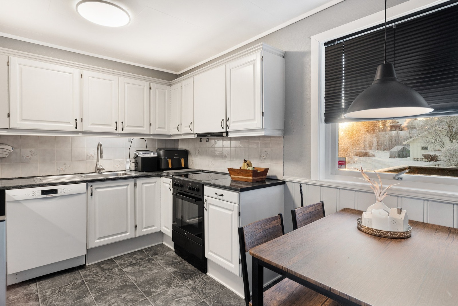 Romslig kjøkken med mye skap- og benkeplass Galleribilde