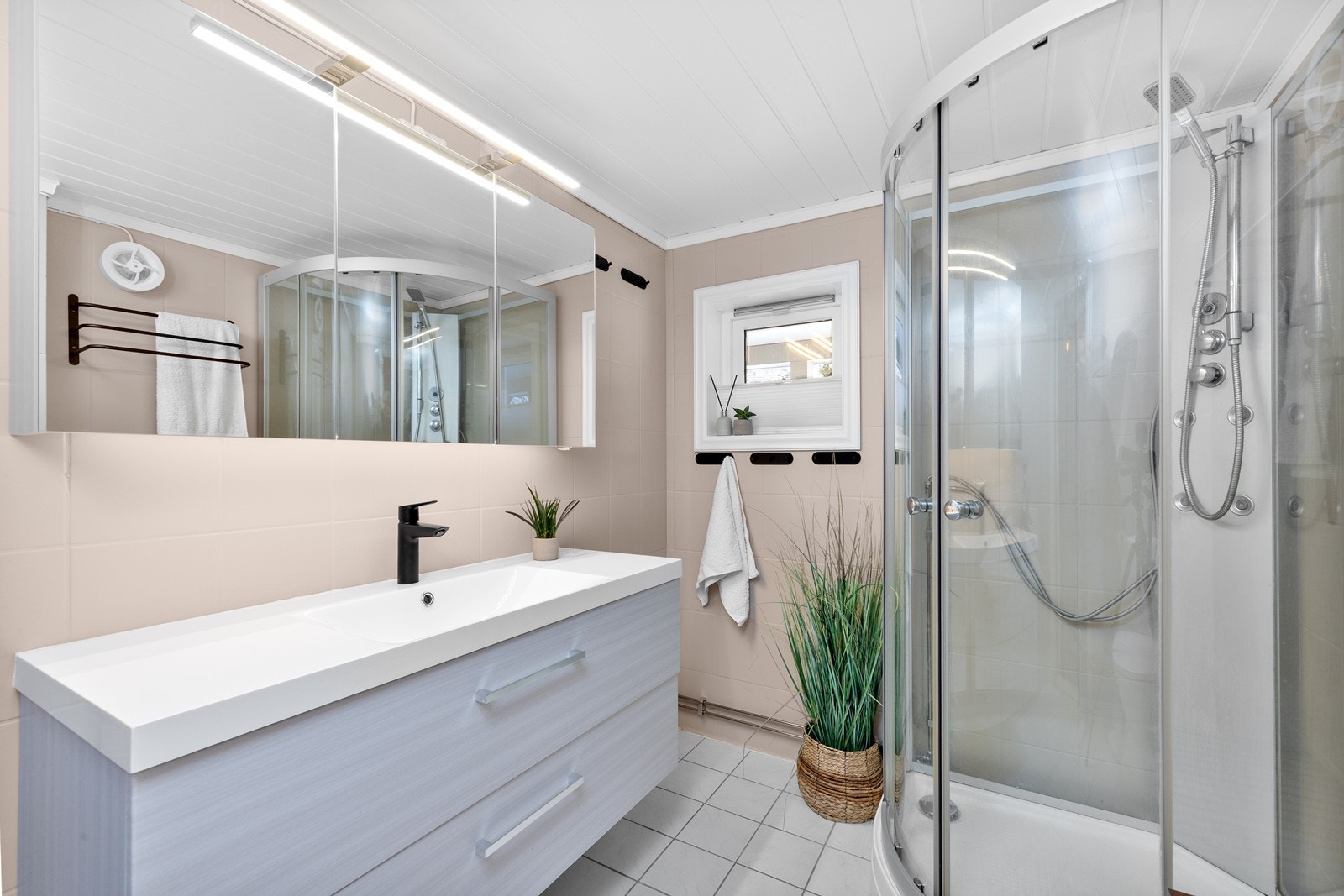 Badet er flislagt og har elektrisk gulvvarme, noe som gir ekstra komfort. Galleribilde