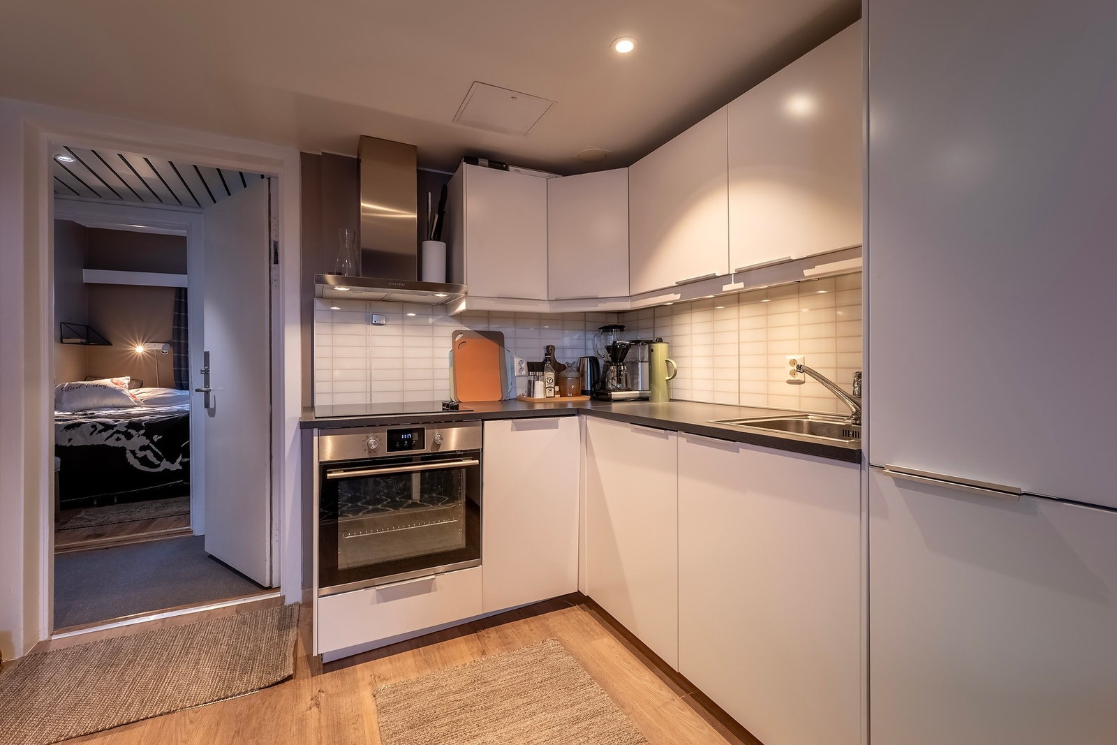 Stilrent kjøkken med integrerte hvitevarer som: platetopp, stekeovn, oppvaskmaskin, kjøl- og fryseskap Galleribilde