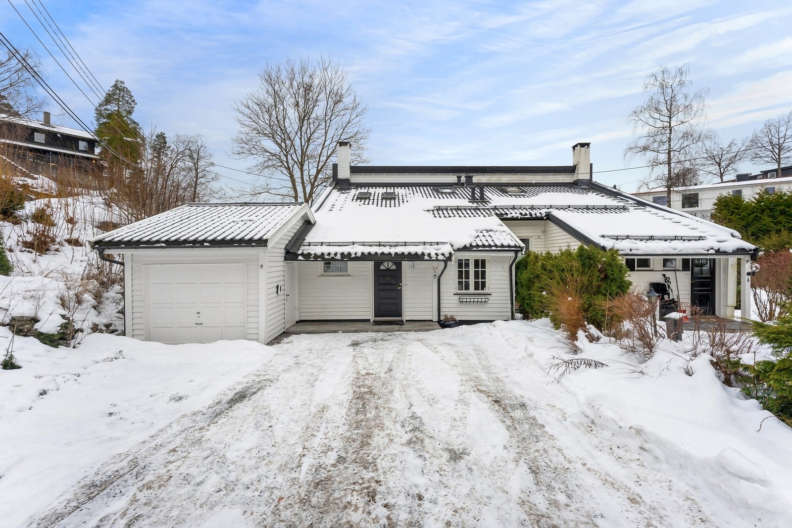 Parkering for en bil i garasje ved boligen, samt parkering på egen gårdsplass i front av boligen med el-bil lader. Flisene forran inngangsdøren har varmekabler. Galleribilde
