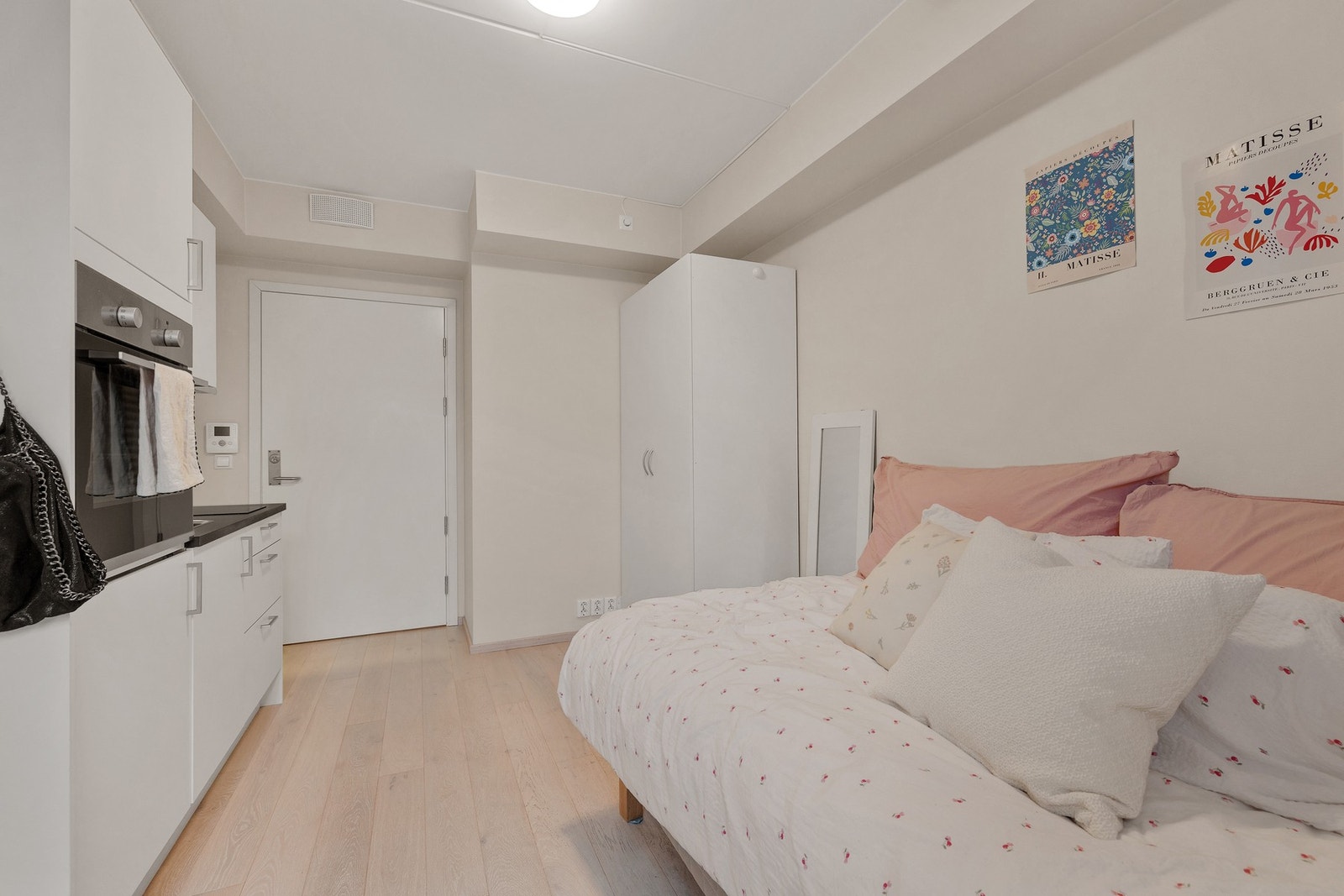 Hybelens oppholdsrom har kjøkkeninnredning med glatte fronter fra HTH og integrerte hvitevarer. Galleribilde