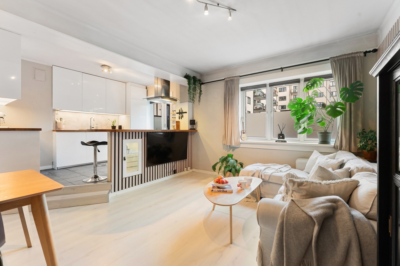 Leiligheten har en sosial planløsning med stue og kjøkken i åpen løsning Galleribilde