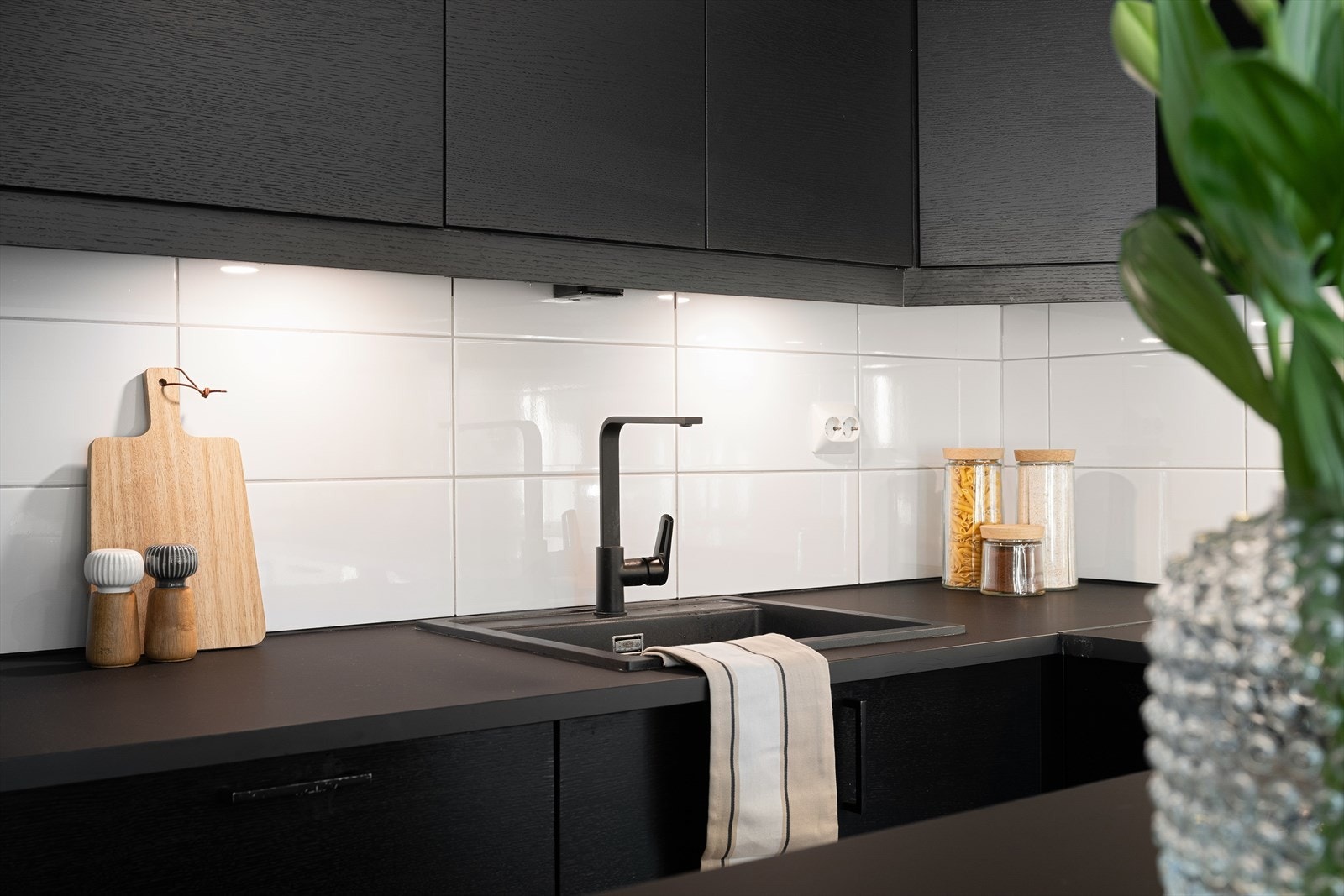 Det er fliser mellom benkeplate og overskap, samt integrert belysning under overskapene som gir både godt arbeidslys og en lun atmosfære. Galleribilde