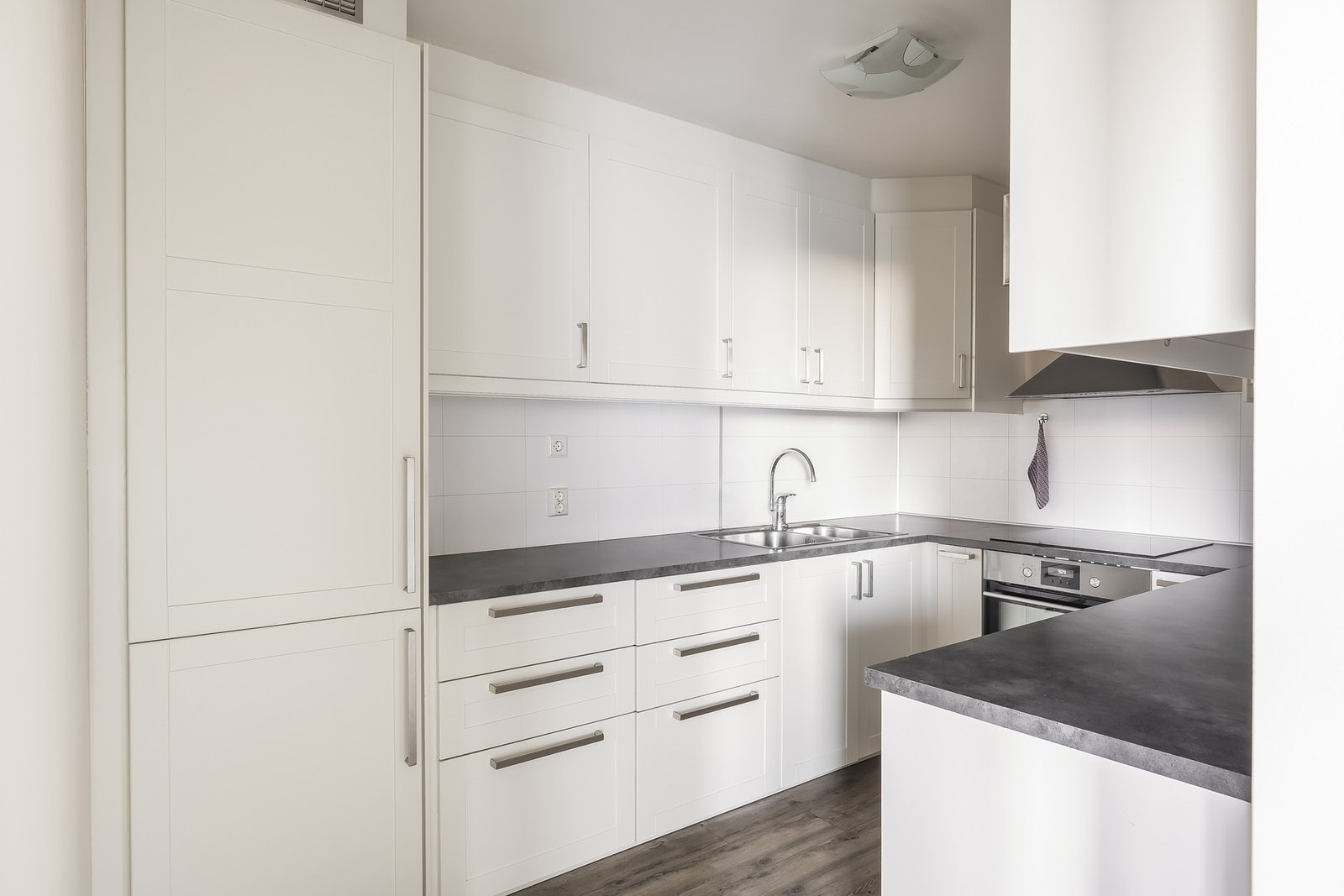 Lyst og stilrent kjøkken med profilerte fronter og rikelig med oppbevaringsplass. Galleribilde