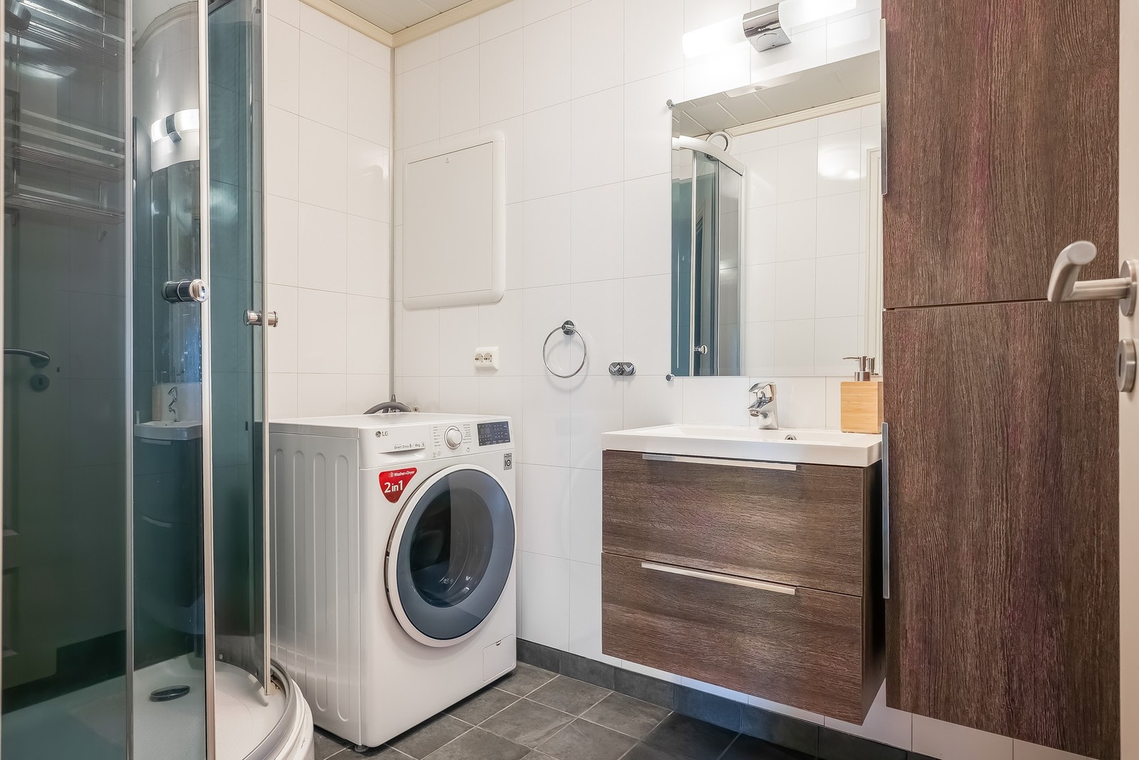 Bad utstyrt med dusjkabinett, servant med servantskap og opplegg for vaskemaskin. Galleribilde