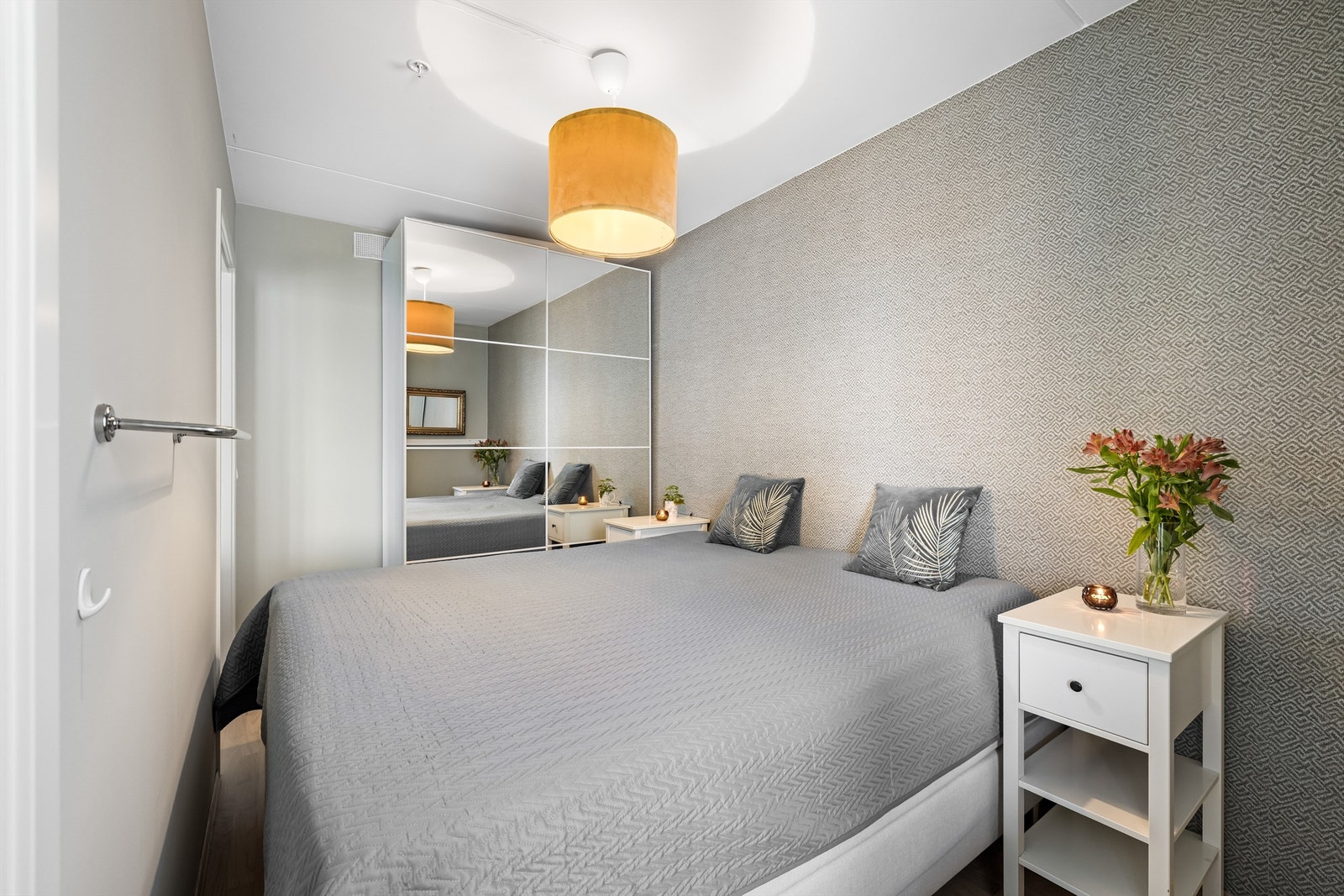 Et stort skyvedørsskap med speilfronter gir godt med oppbevaringsplass Galleribilde