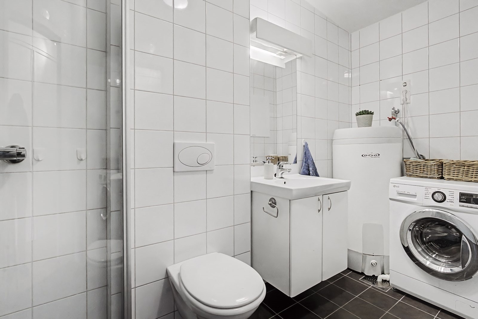 Innerst har badet opplegg for både vaskemaskin og tørketrommel, samt ekstra sluk i gulvet. Galleribilde