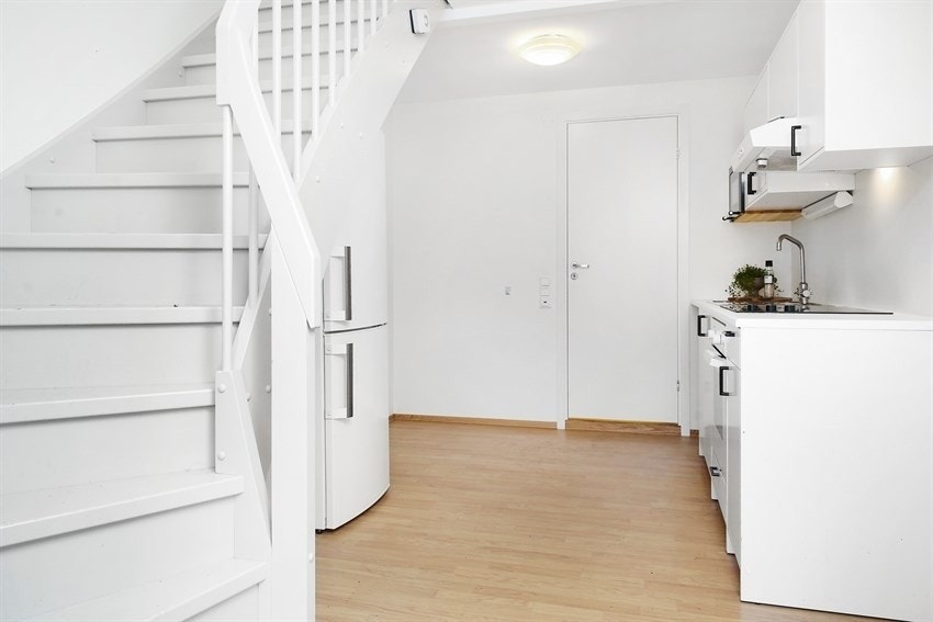 Inngangsparti med fullstendig kjøkken. Ledig leilighet ligger til venstre for kjøleskapet. Galleribilde