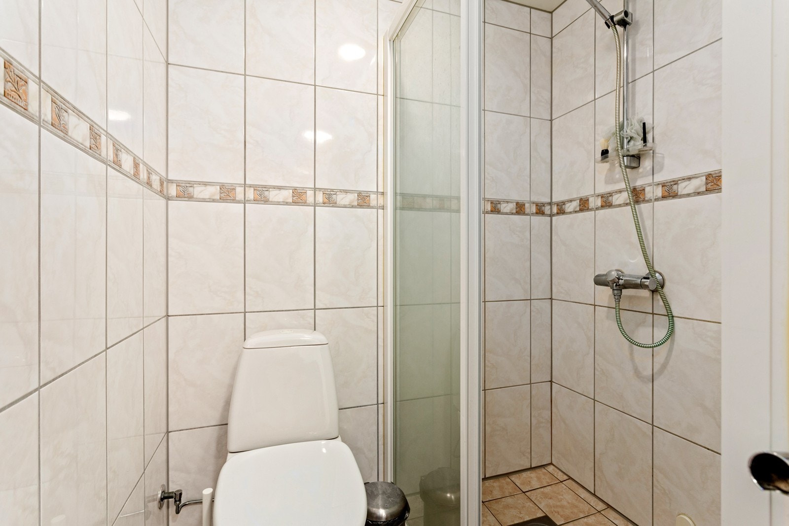 Badet er elles utstyrt med dusjnisje med skyvedør, toalett og baderomsinnredning med nedfelt servant. Galleribilde