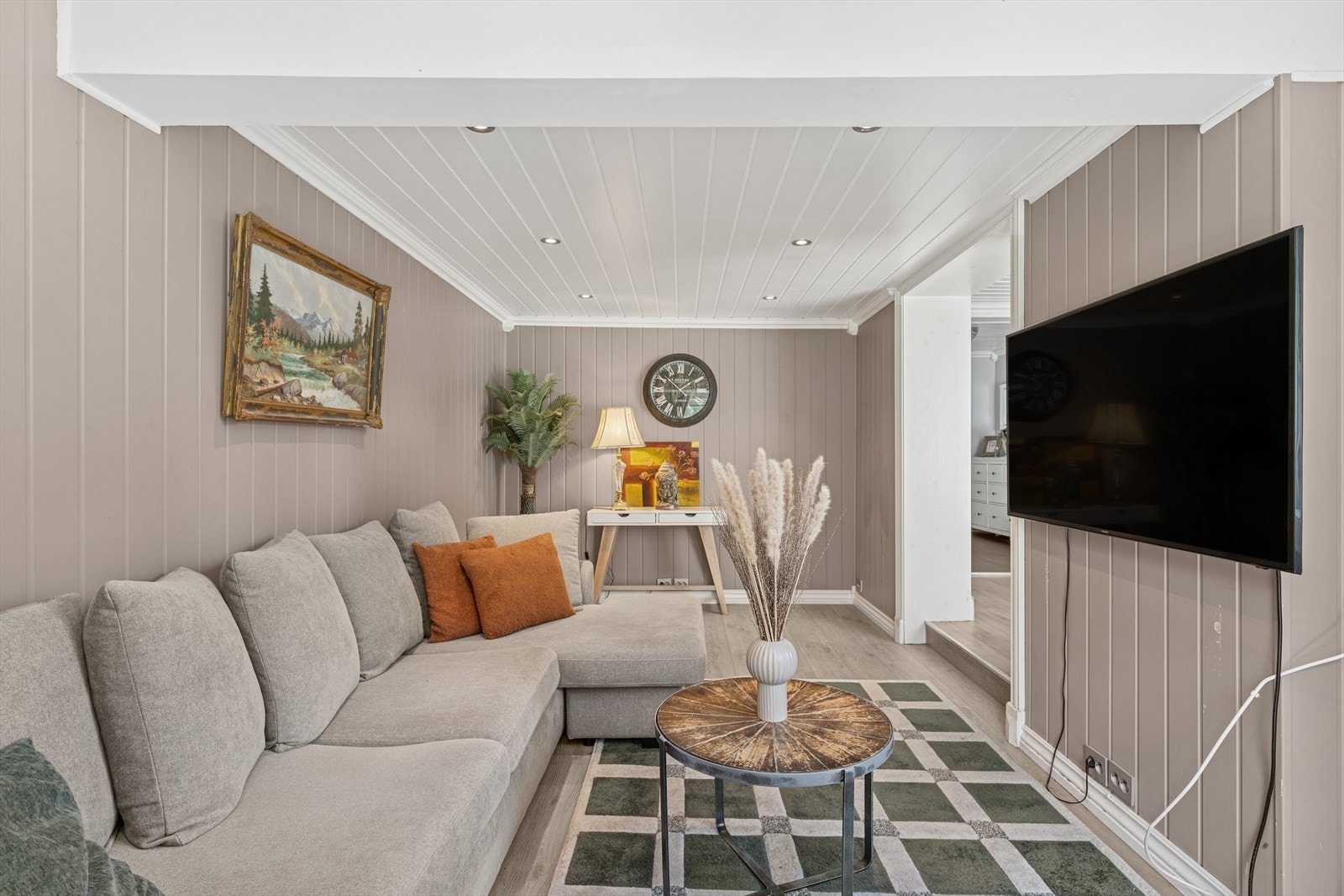 TV-stue med downlights i himling og malt i duse farger. Sofakroken finner naturlig plass, og TV kan plasseres på vegg. Rommet er opprinnelig overbygd balkong, omsøknad sendt 16.06.25. Galleribilde