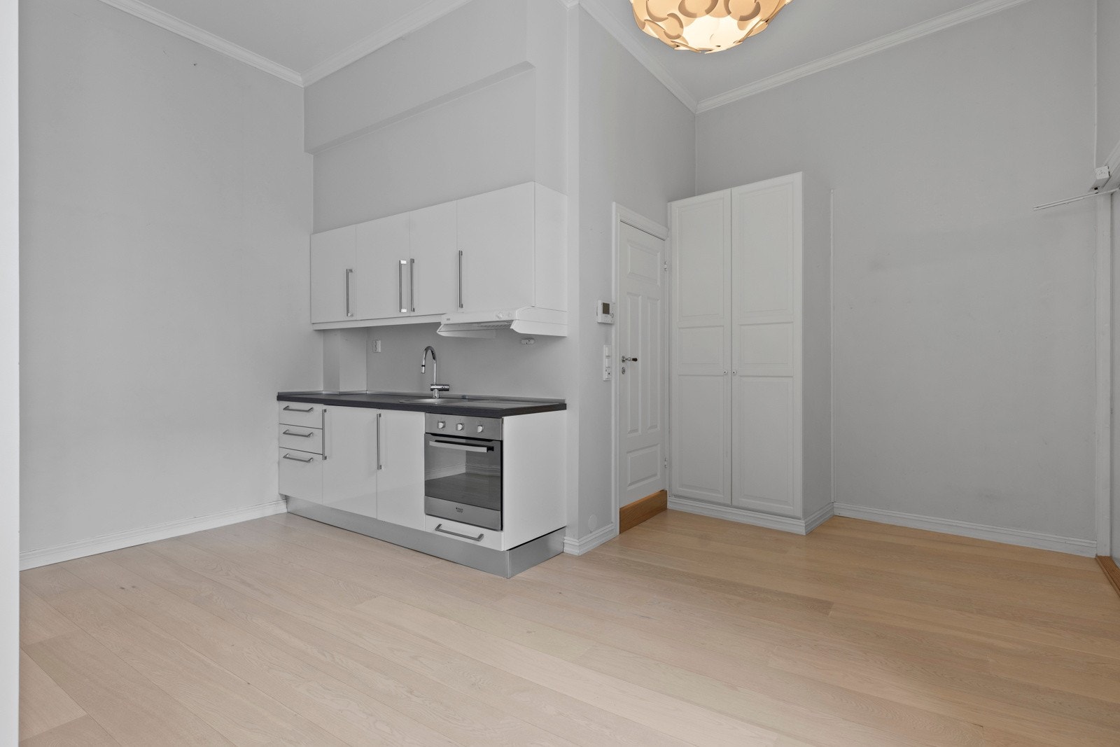 Her finner vi et moderne kjøkken med glatte fronter og laminatbenkeplate - praktisk og lekkert. Galleribilde