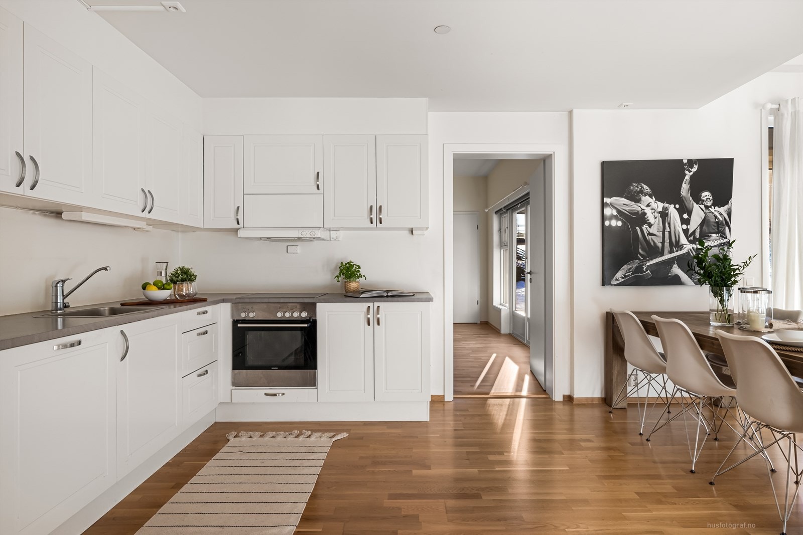 Kjøkkeninnredning med hvite profilerte fronter og benkeplate av slitesterk laminat. Galleribilde