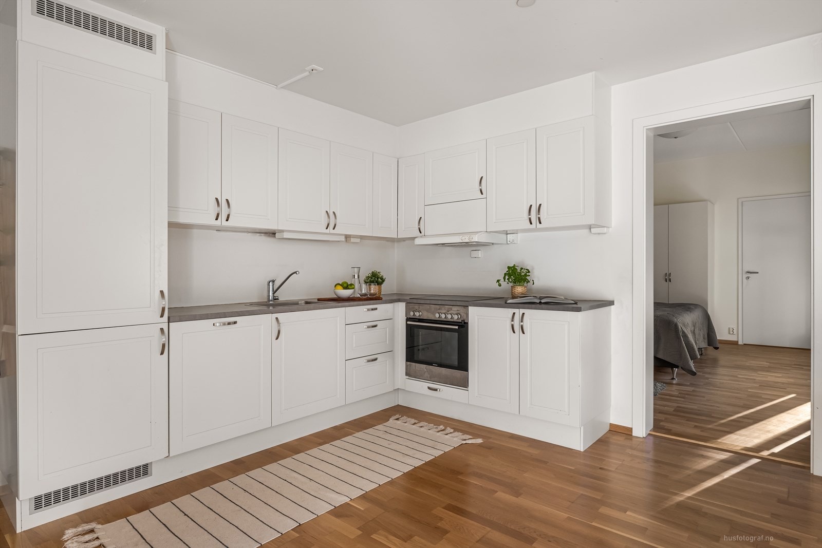 Integrerte hvitevarer med kjøle-/fryseskap, oppvaskmaskin, komfyr og platetopp. Galleribilde