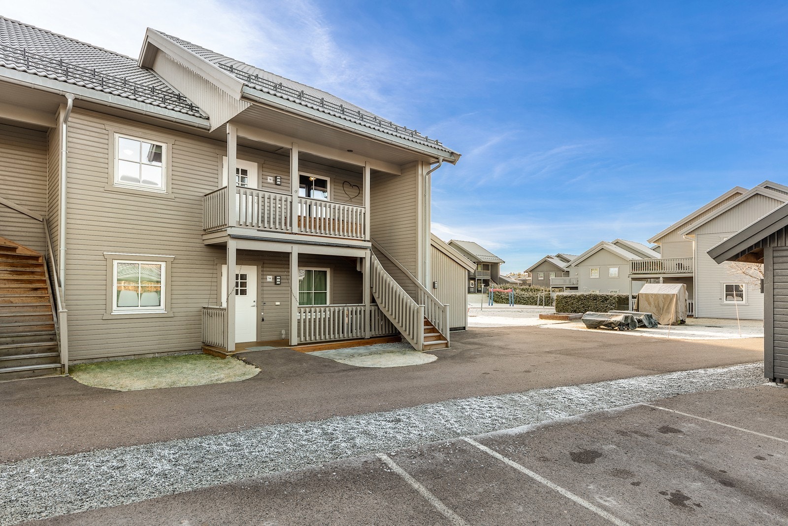 Sameiets tomt er opparbeidet med gressplen, asfalterte veier og parkeringsplasser. Galleribilde