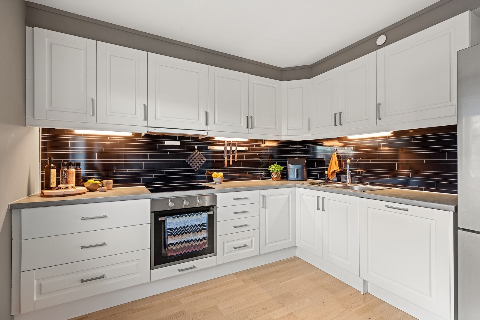 Her finner du nedfelt oppvaskkum og koketopp, samt integrerte hvitevarer som stekeovn og oppvaskmaskin. Det er også tilrettelagt plass til kombiskap. Galleribilde