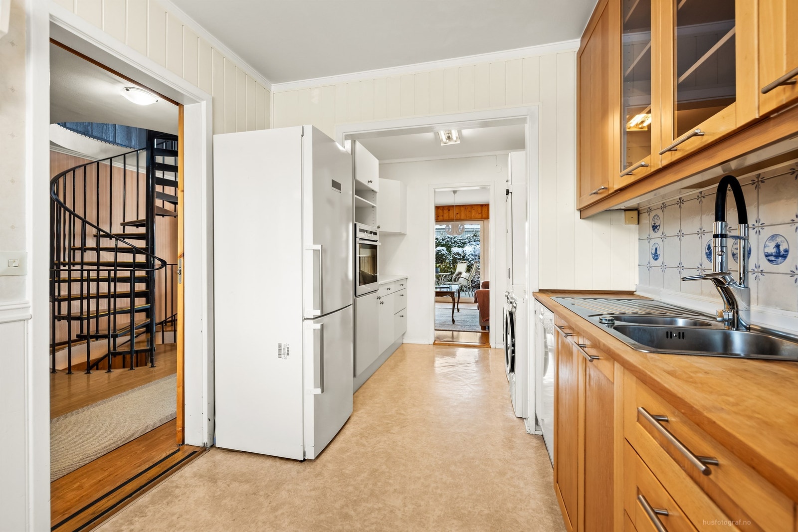 Flislagte felt på vegg over benkeplate og benkeplater av tre samt laminat Galleribilde