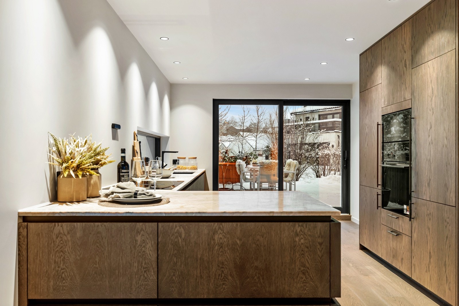 Kjøkkenet fremstår stilrent og funksjonelt med plassbygde løsninger i mørke fronter og en benkeplate i steinkompositt. Galleribilde