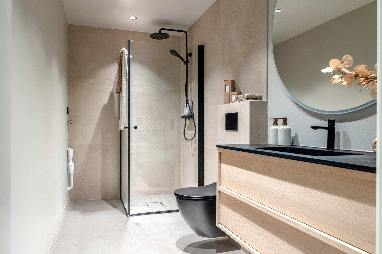 Bad utstyrt med dusjhjørne, vegghengt toalett, servant og opplegg for vaskemaskin. Galleribilde