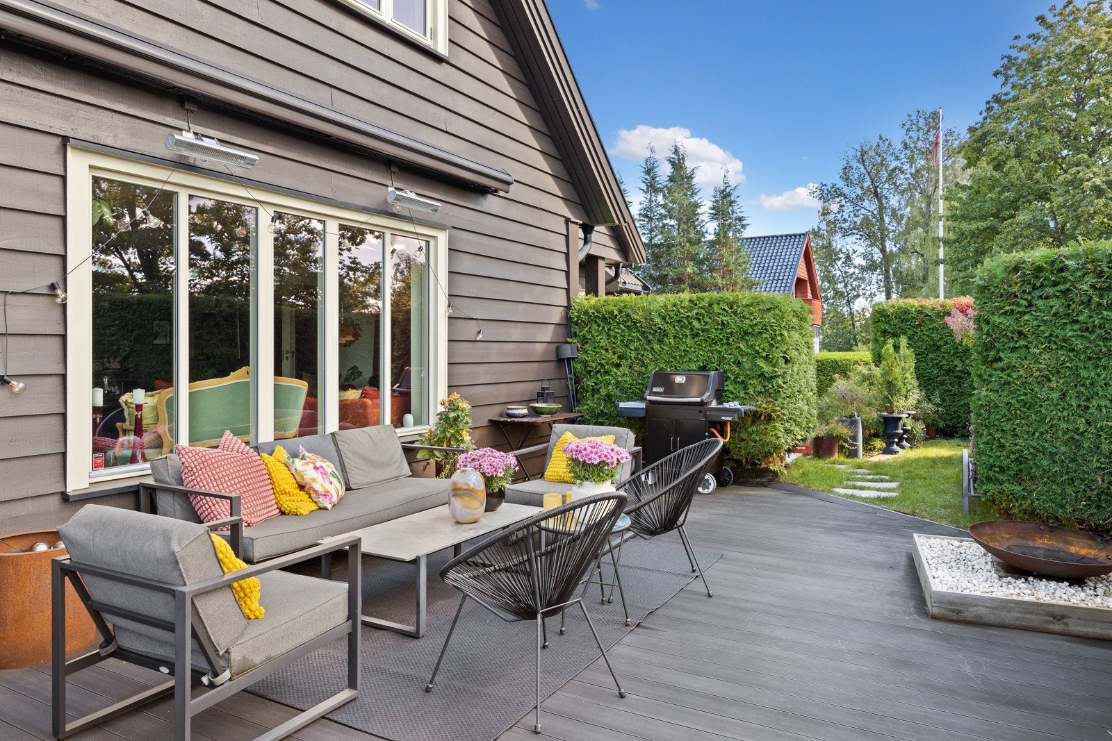 Solrik terrasse med tilgang fra stuen og fra hovedsoverommet. Her kan solen nytes store deler av dagen og til sent på kveld i sommerhalvåret (bilde tatt sensommer 2025). Galleribilde