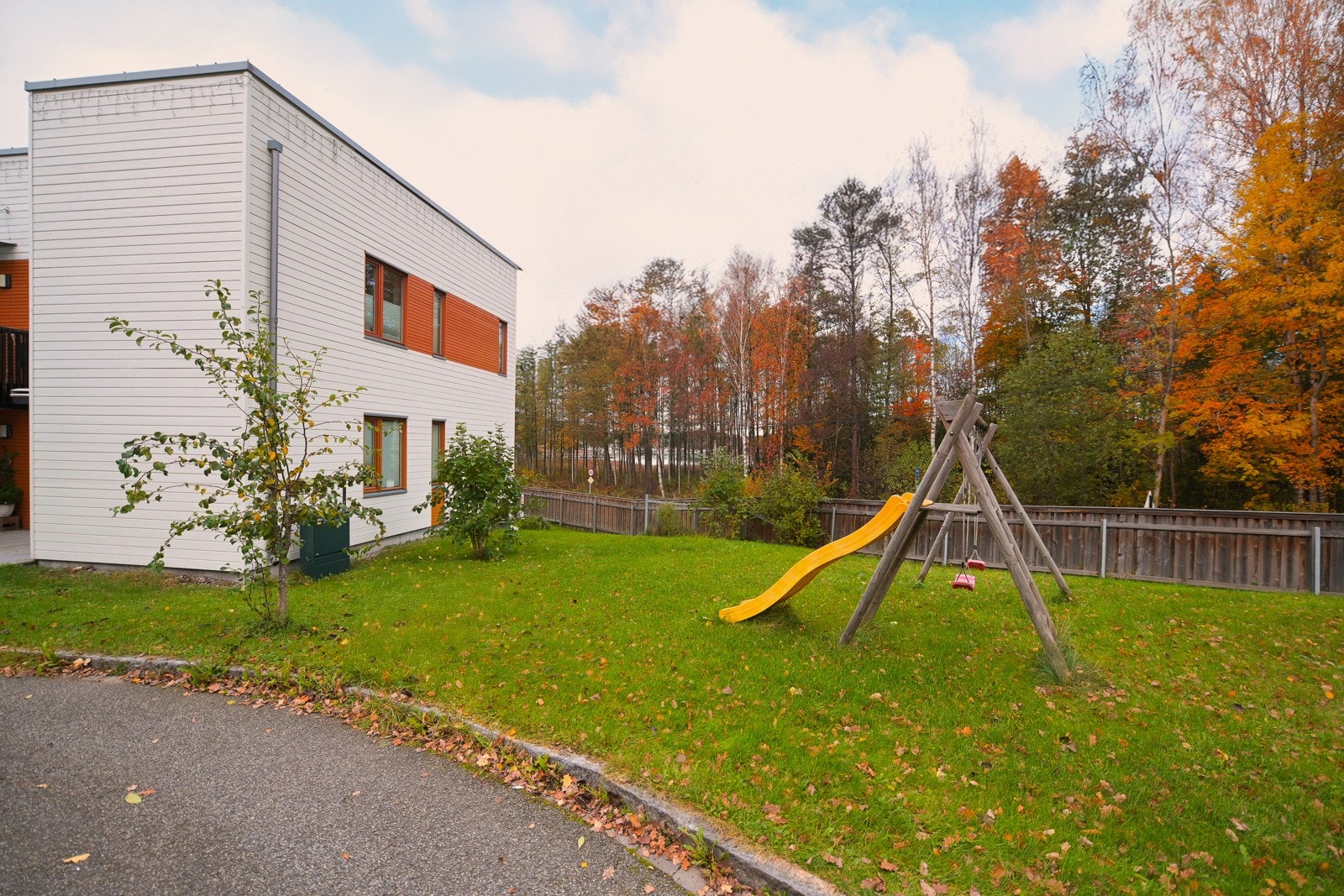Gressplener og beplantning rundt boligene. Lekeplass på området. Galleribilde