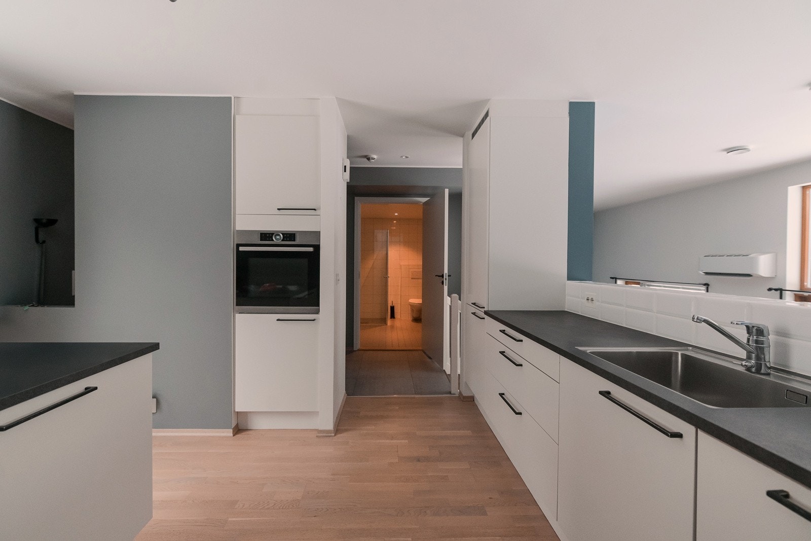 Lys og pen innredning med slette fronter, og benkeplate av laminat og nedfelt oppvaskkum. Integrert stekeovn, platetopp, oppvaskmaskin og kjøleskap med fryser. Galleribilde