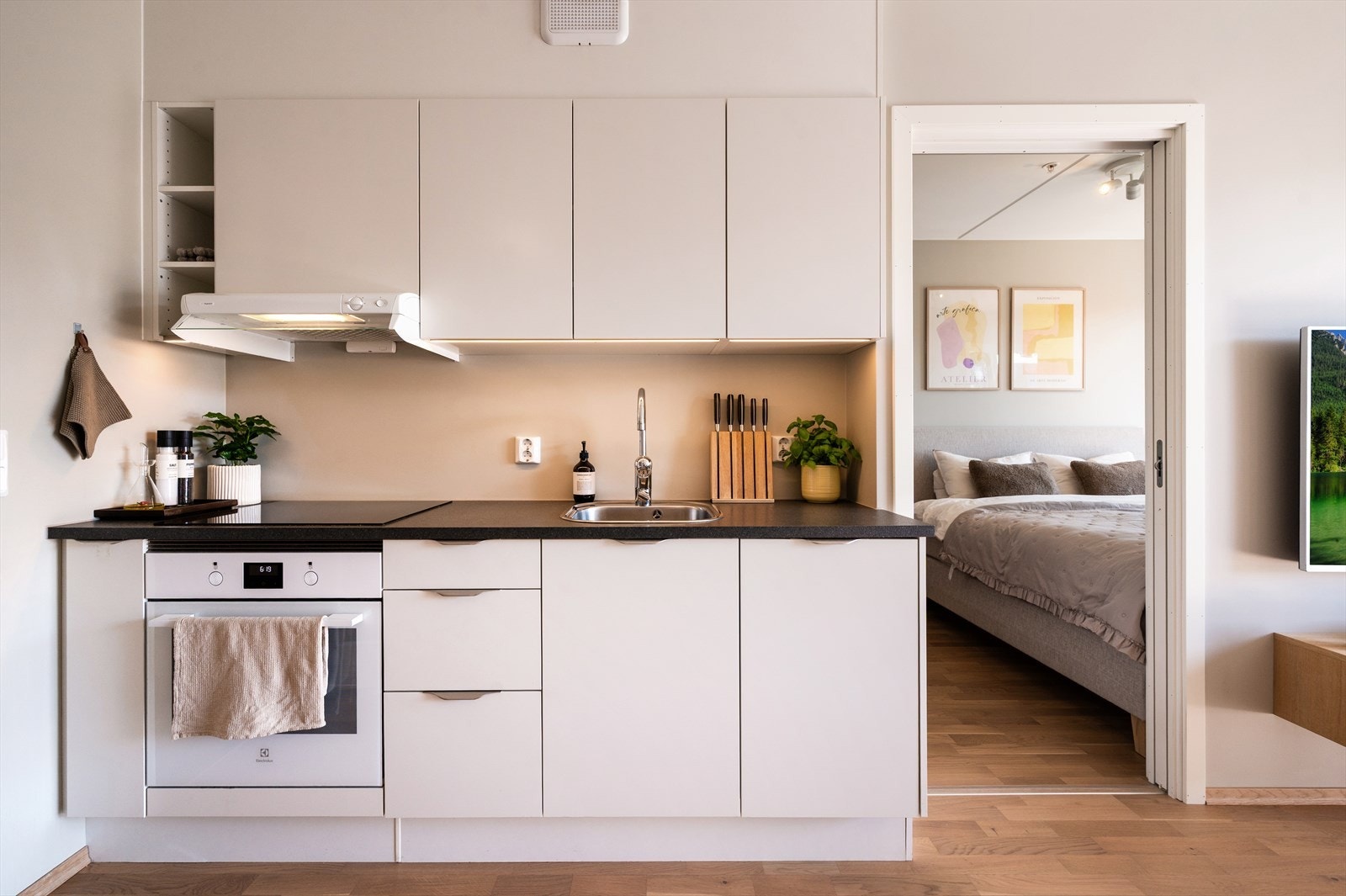 Innholdsrikt kjøkken med god skapplass for oppbevaring. Innredning med hvite glatte skapfronter, laminat benkeplater, nedfelt rustfri oppvaskkum og et greps armatur. Integrerte hvitevarer som oppvaskmaskin, stekeovn og induksjon koketopp. Galleribilde