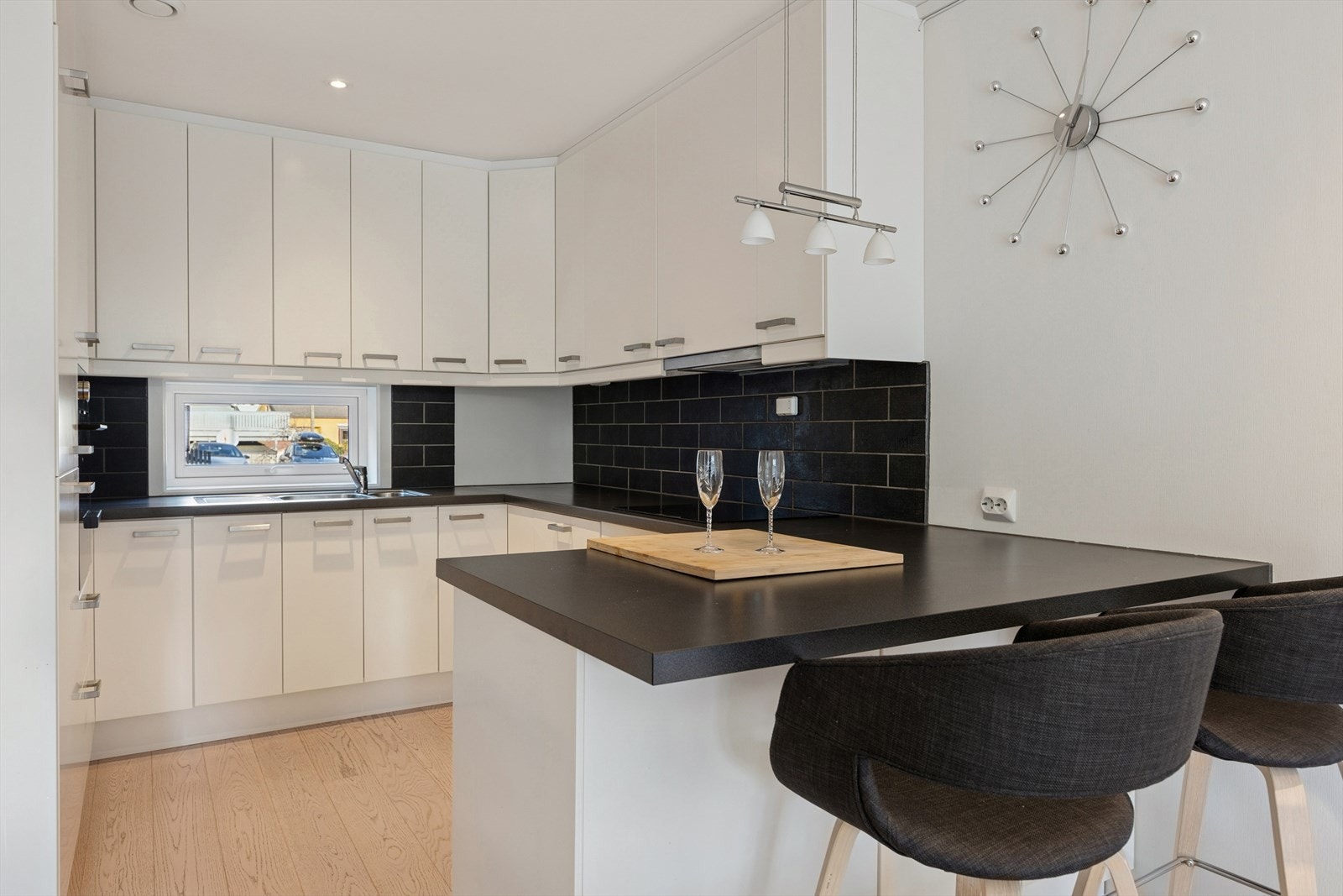 Kjøkkenet er stilrent innredet med hvite, slette fronter og mørk benkeplate i laminat. Et godt utnyttet kjøkken som gir god lagringsplass i skap og skuffer, samt gode arbeidsflater på benk. Galleribilde