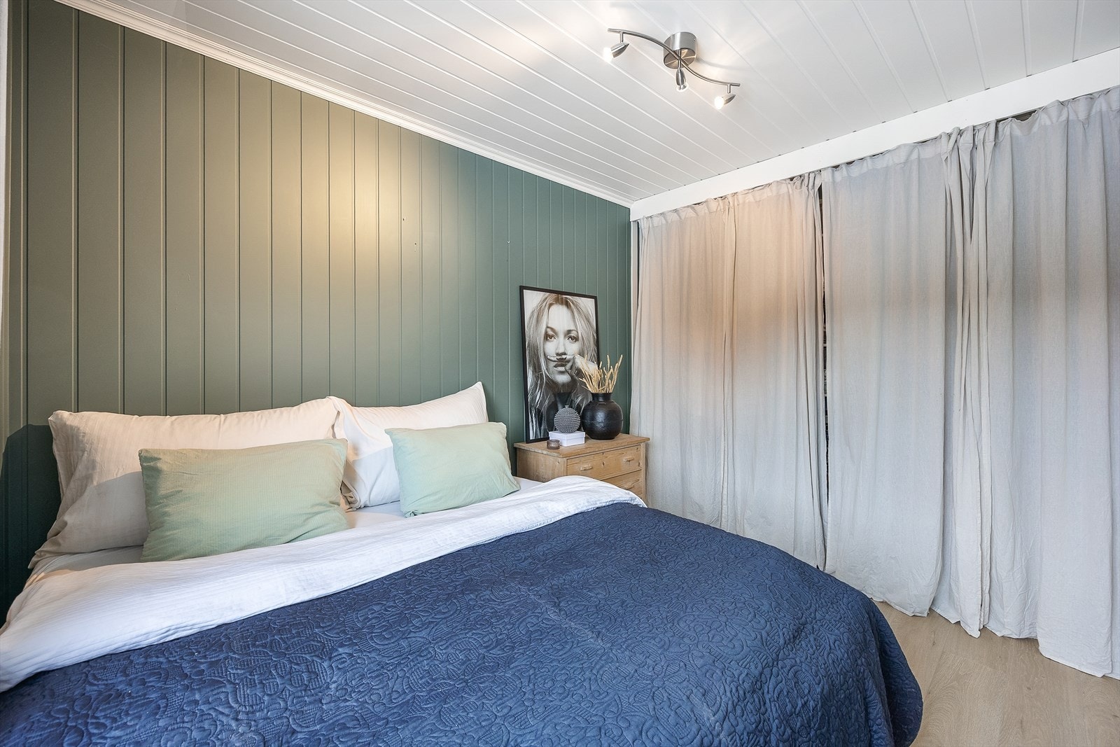 Rommet har en åpen garderobeløsning langs den ene veggen, med hyller, skuffer og klesoppheng. Galleribilde