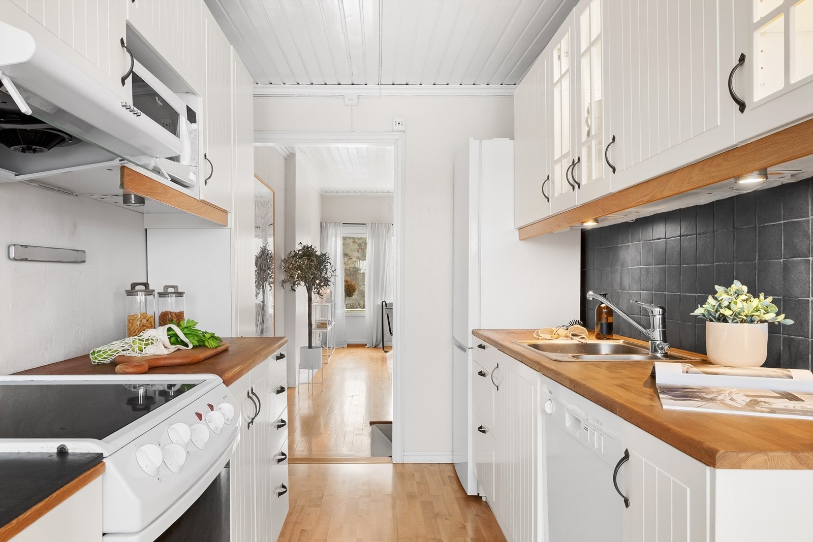 Det er dobbel, nedfelt oppvaskkum og hvitevarer bestående av frittstående komfyr, oppvaskmaskin samt kjøle- og fryseskap. Galleribilde