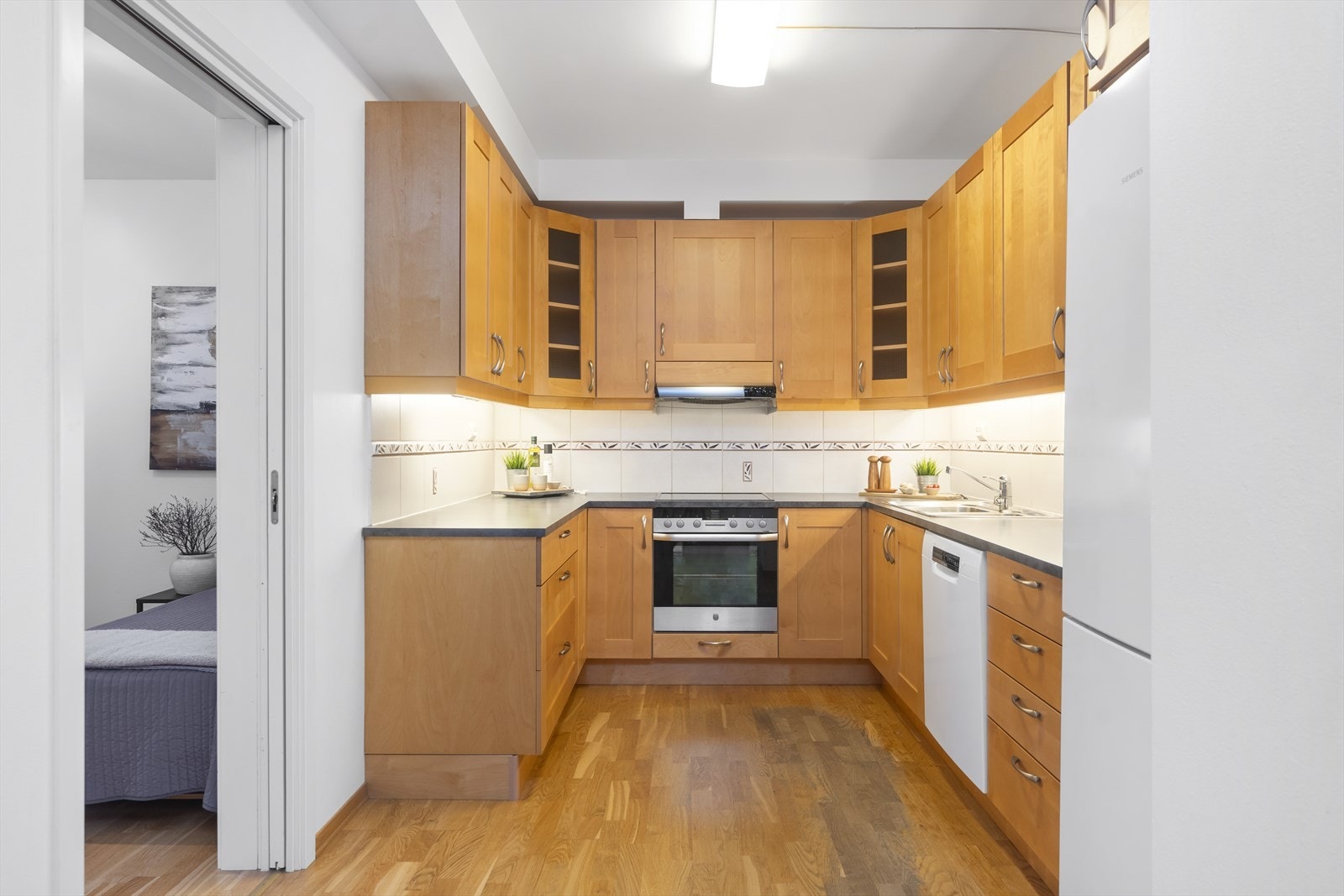 Kjøkkenet er av god størrelse med mye benkplass og masse skapplass Galleribilde