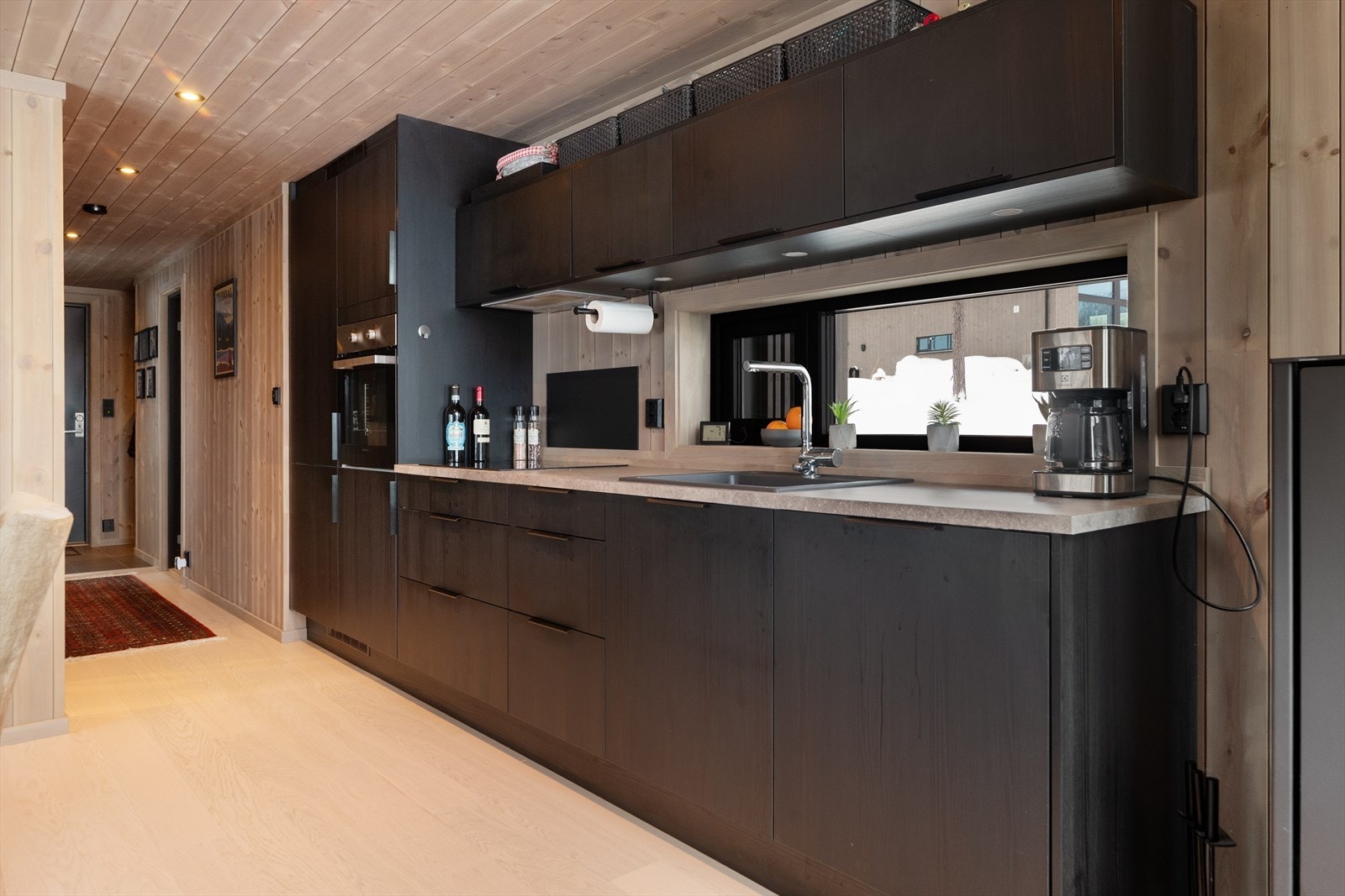 Moderne kjøkken med god skapplass. Kjøkkenet har flott innredning med glatte fronter og benkeplate av laminat med nedfelt induksjonstopp. Integrerte hvitevarer er kjøl/fryseskap, oppvaskmaskin, komfyr og stekeovn. Over ventilator med avtrekk ut. Galleribilde