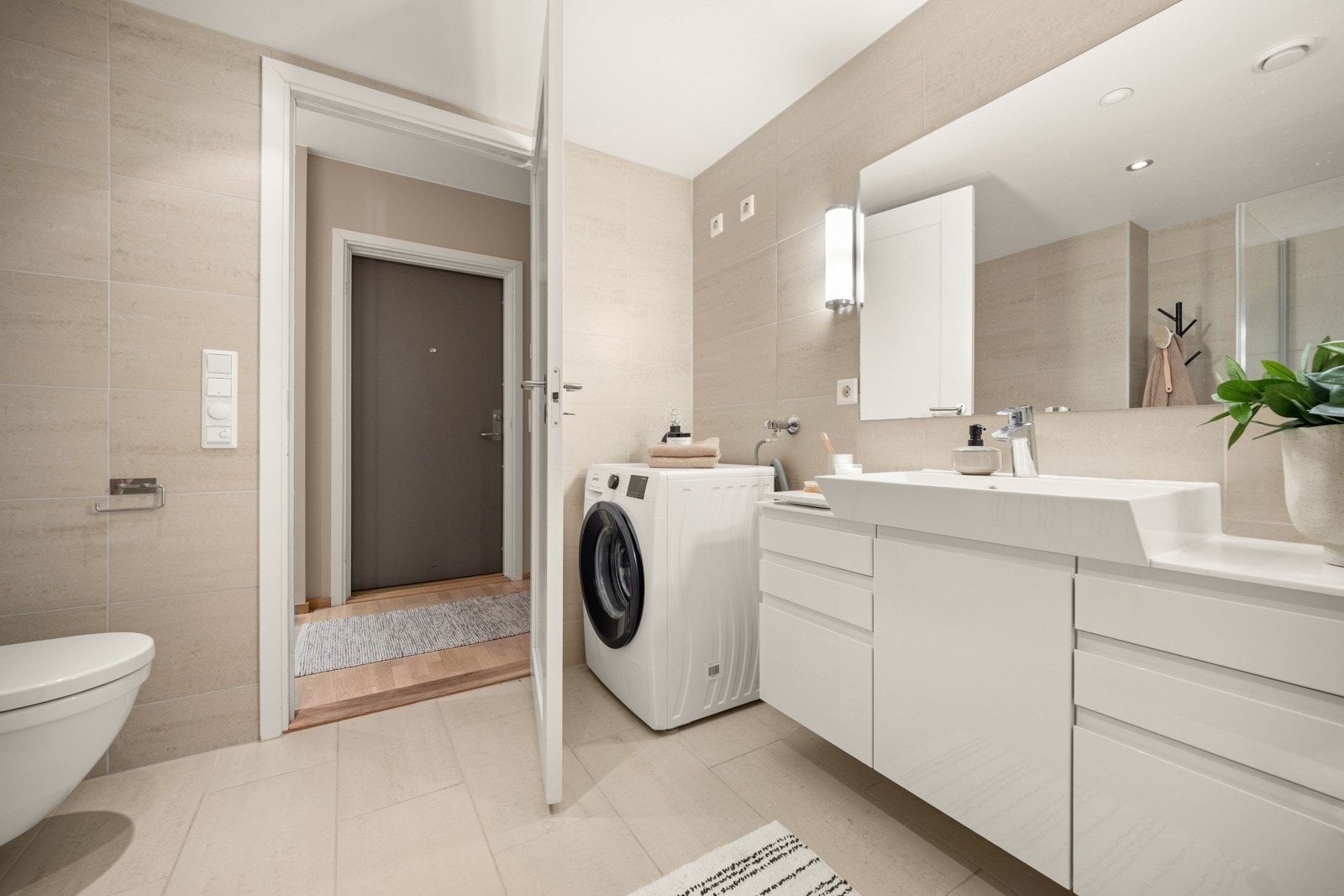 Opplegg for vaskemaskin ved siden av servantinnredningen. Galleribilde