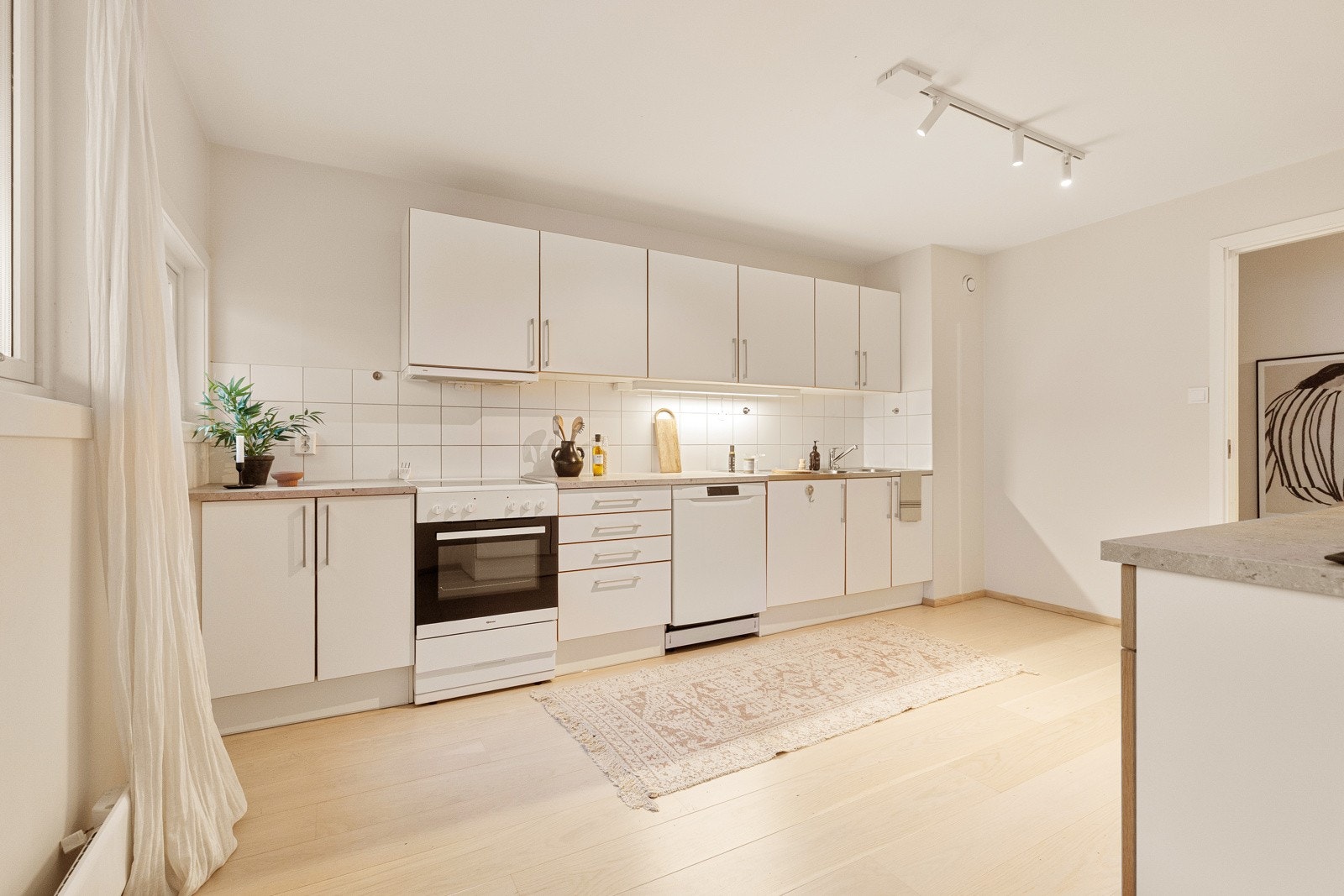 Tvis kjøkken med glatte fronter og laminat benkeplate med helstøpt oppvaskkum i stål med 2 kummer og ettgreps armatur fra Oras. Galleribilde