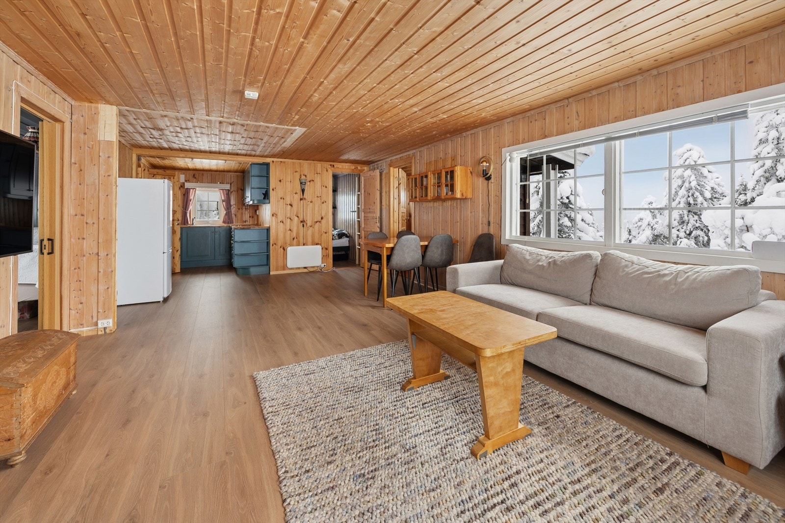 På gulvet er det lagt laminat og vegger og himling består av trepanel. Galleribilde